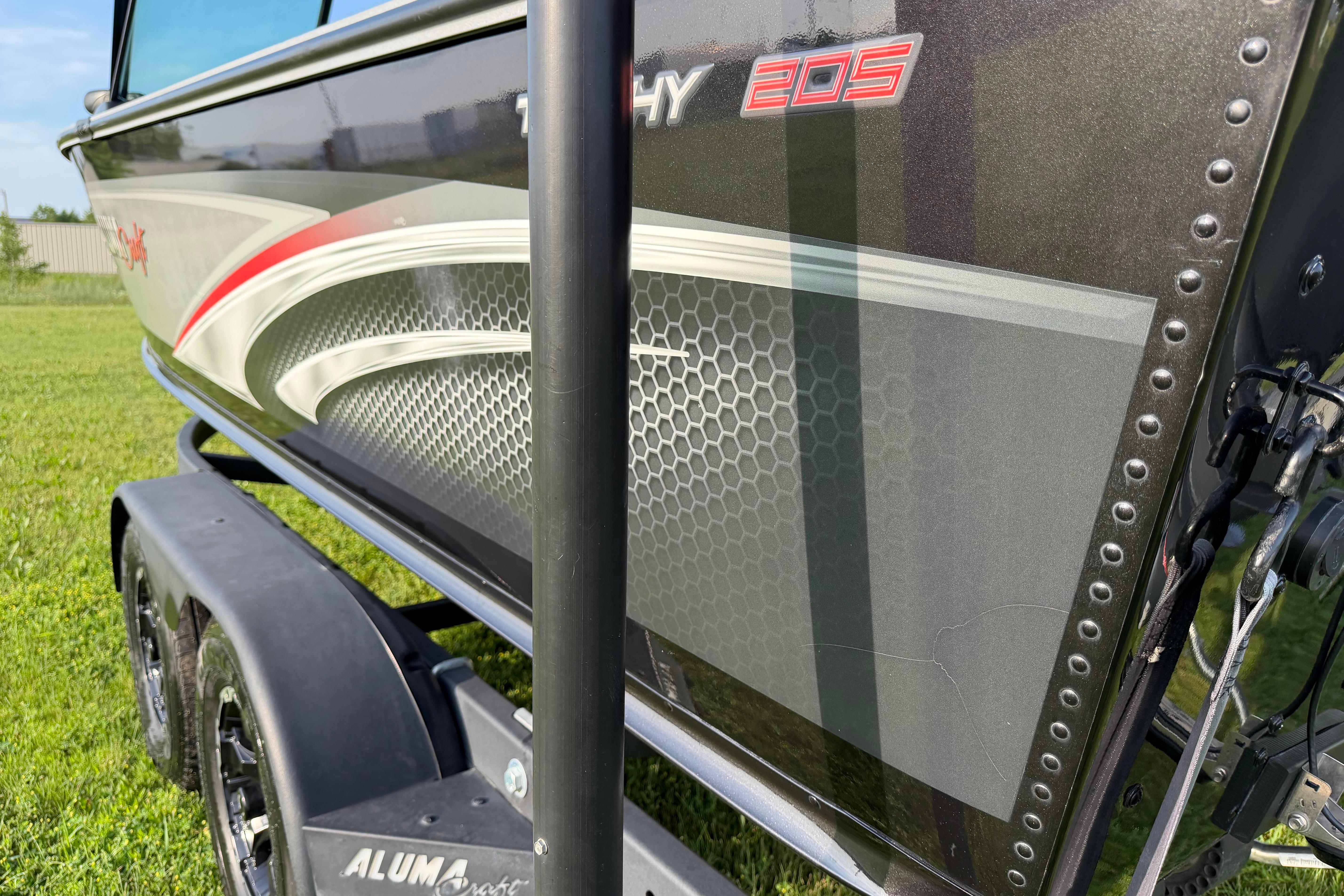 2019 Alumacraft Trophy 205 boat with sleek design and vibrant graphics on trailer.