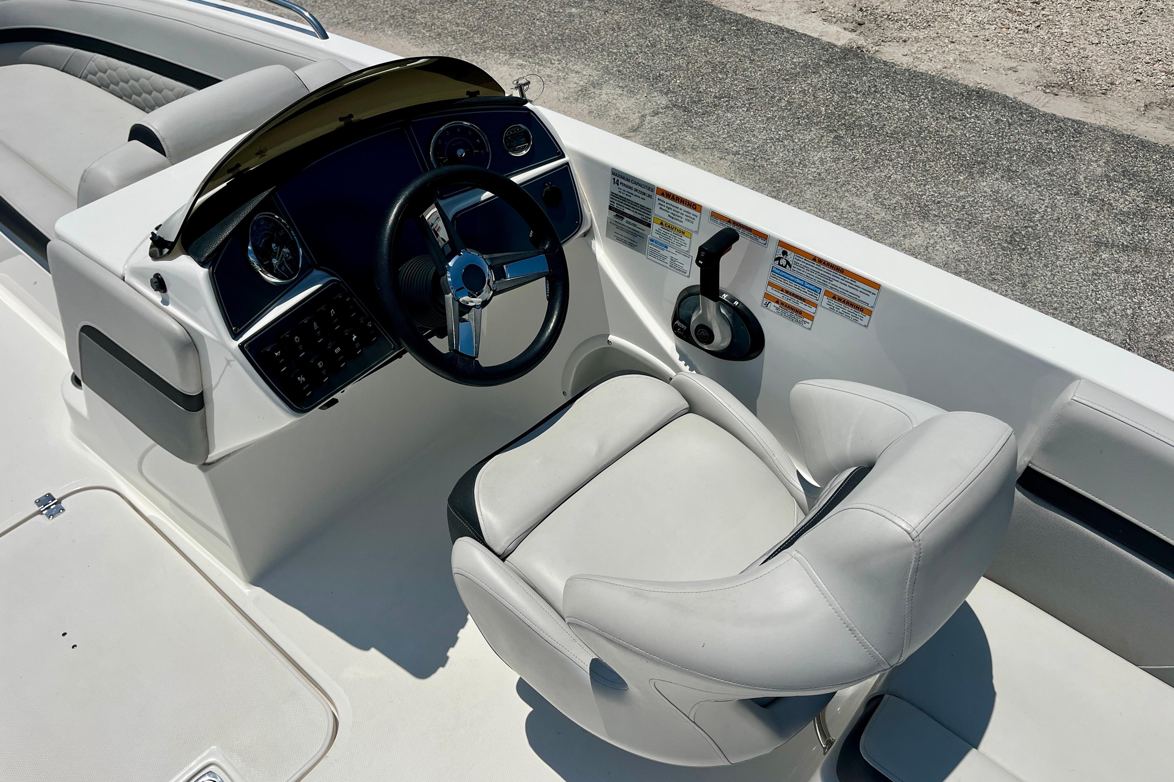 2024 Hurricane Sundeck Sport 218 OB boat cockpit with steering wheel and captain's chair.