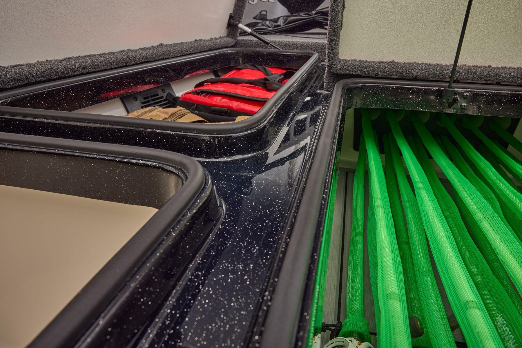 Manufacturer Provided Image: 2026 Ranger 620xFS Pro boat storage compartments with life jackets and green rod holders.