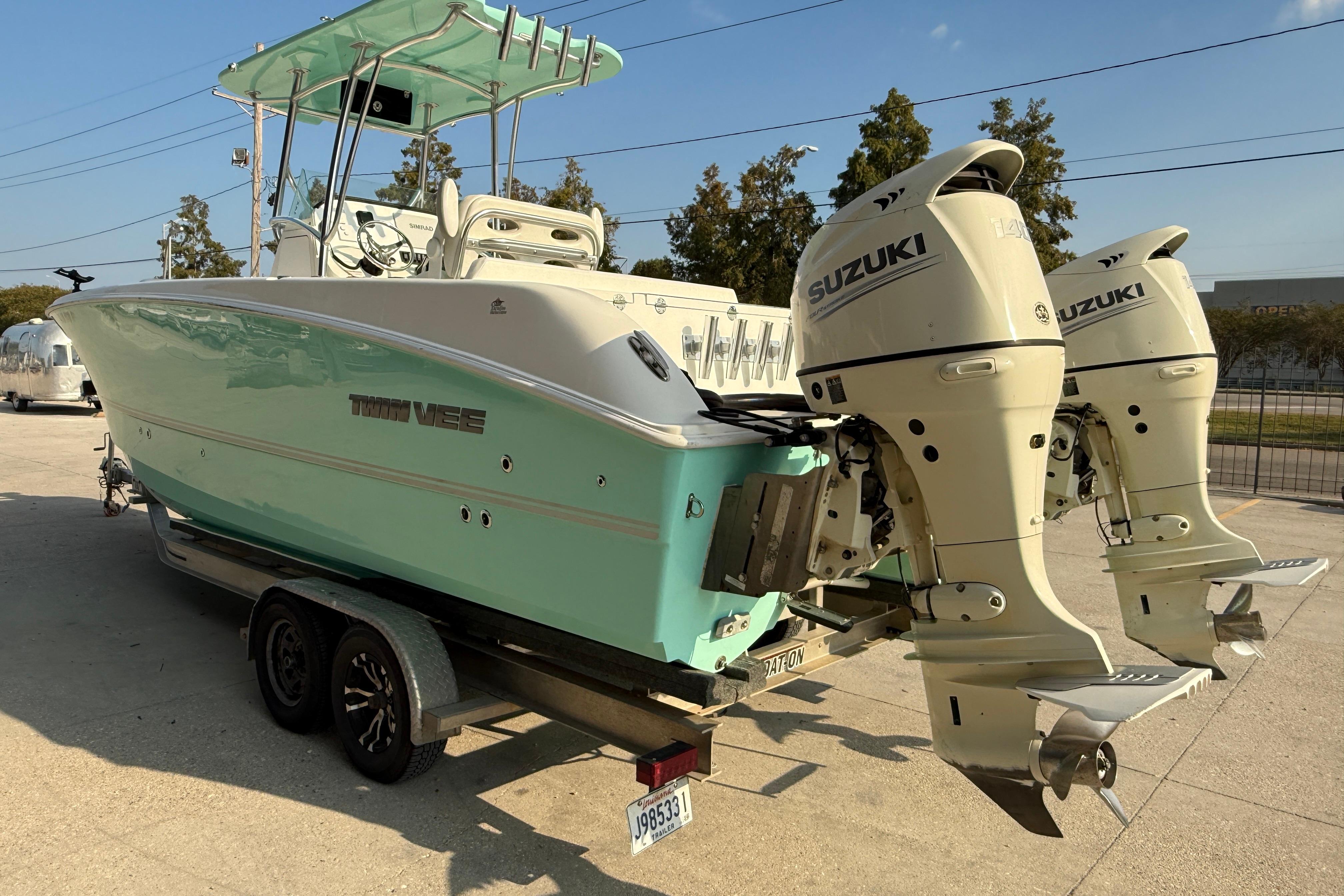 2020 Twin Vee 240 GFX CC boat with dual Suzuki outboard motors on a trailer.