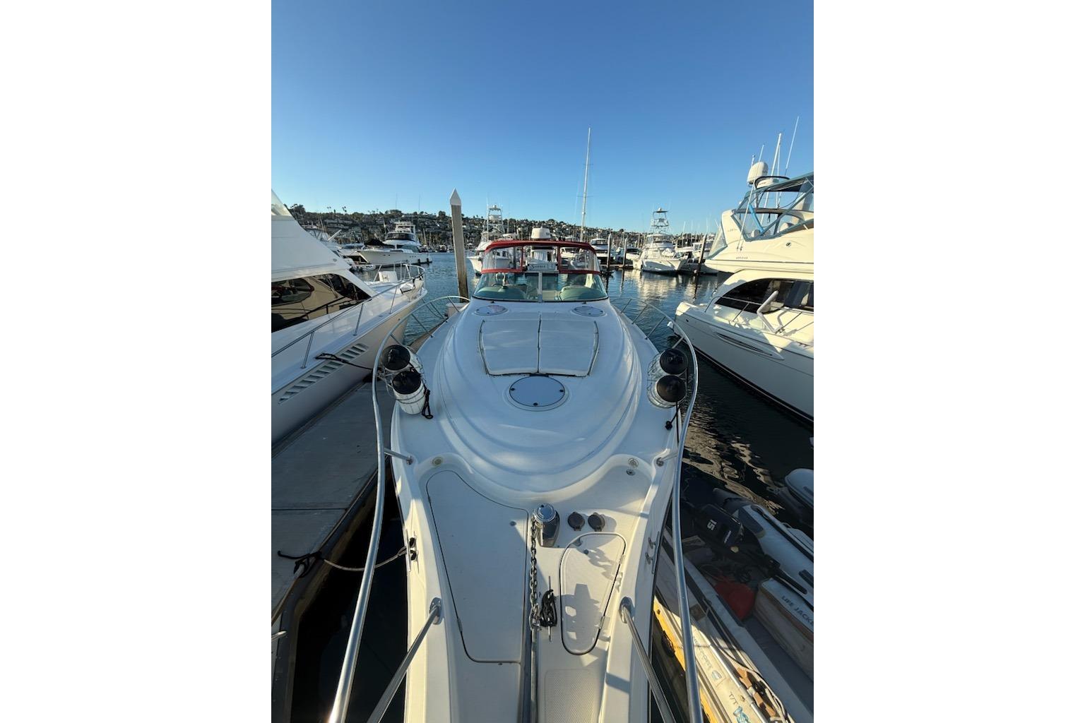 1998 Maxum 3700 SCR yacht docked in a marina under clear blue skies.