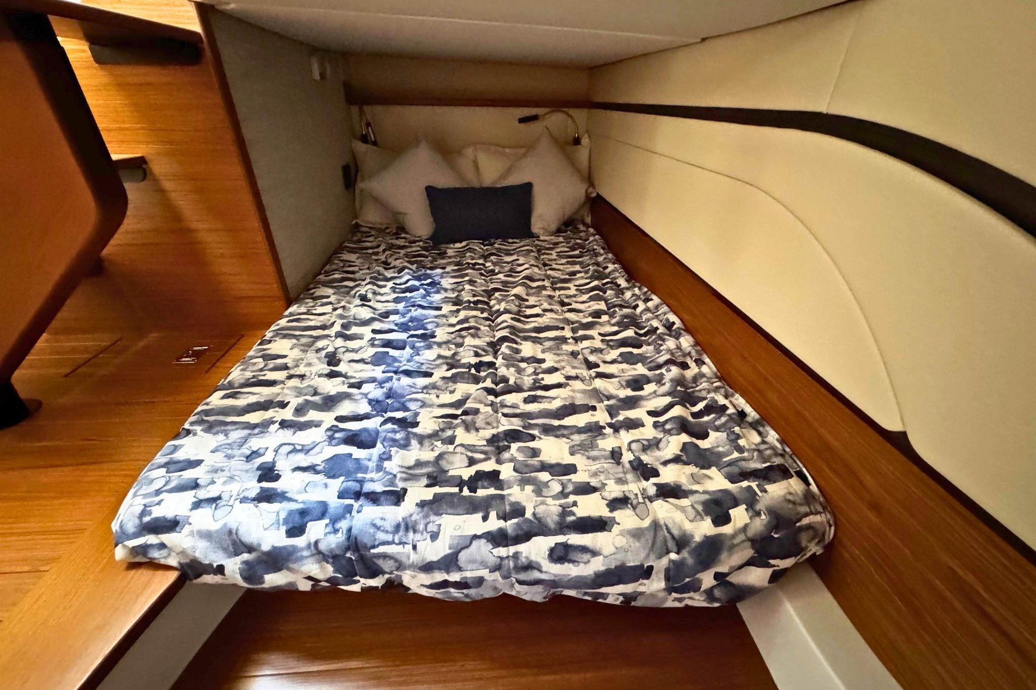 Cozy cabin interior of 2027 Tiara Yachts 39 LE with patterned bedding and wooden accents.