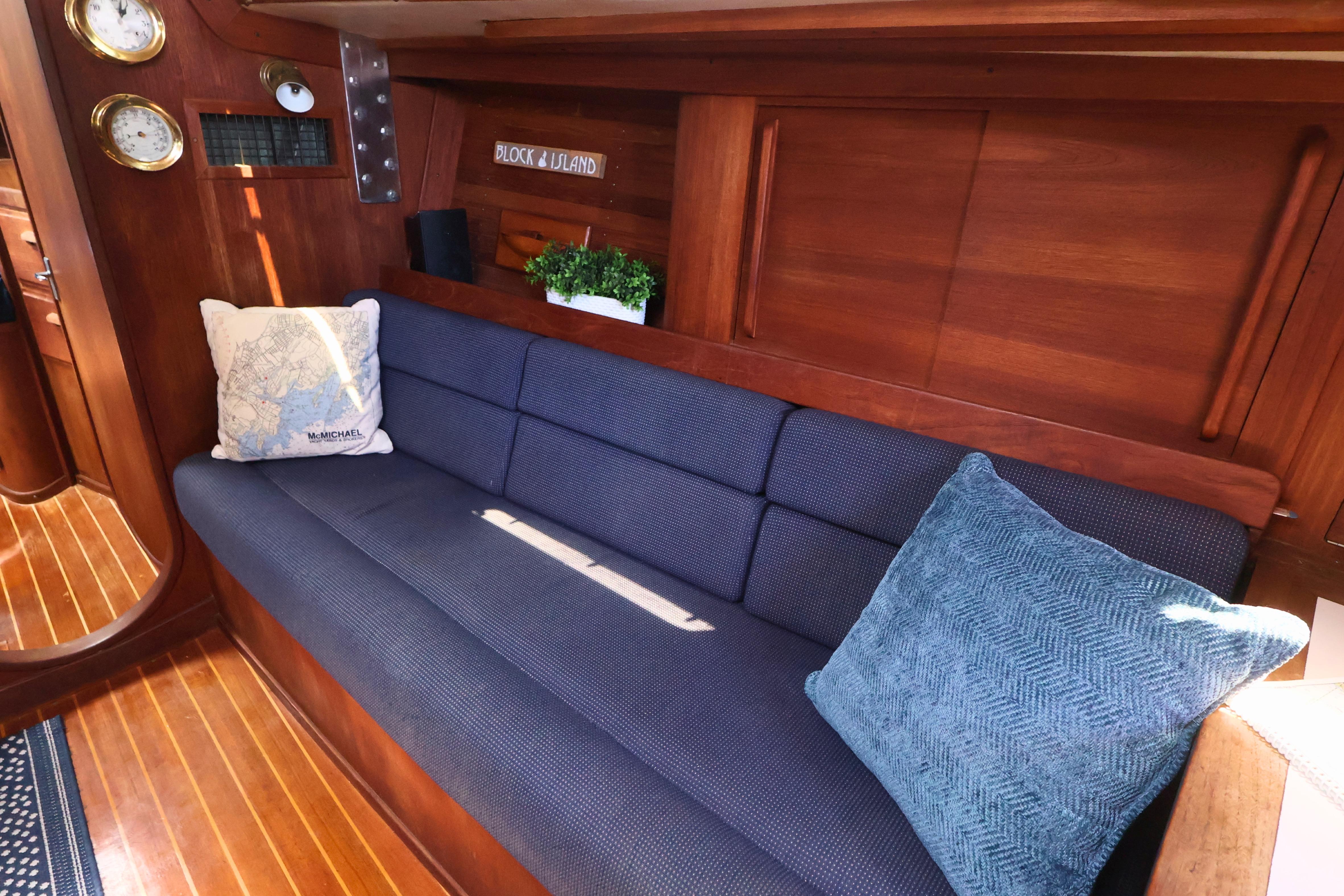 Interior of 1989 J Boat J 40 with blue sofa and nautical decor.