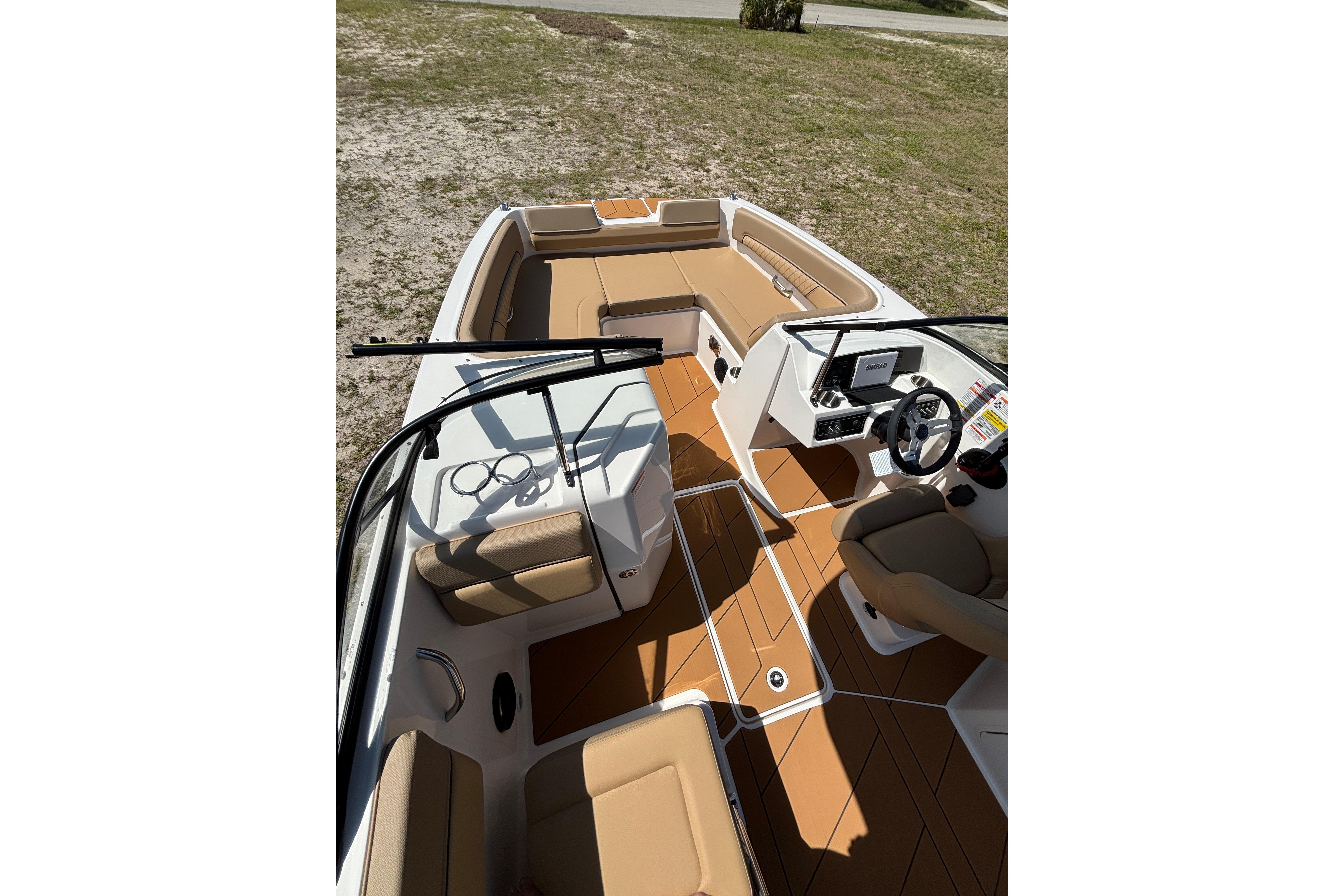 2026 Bayliner D22 boat interior with tan seating and modern dashboard.