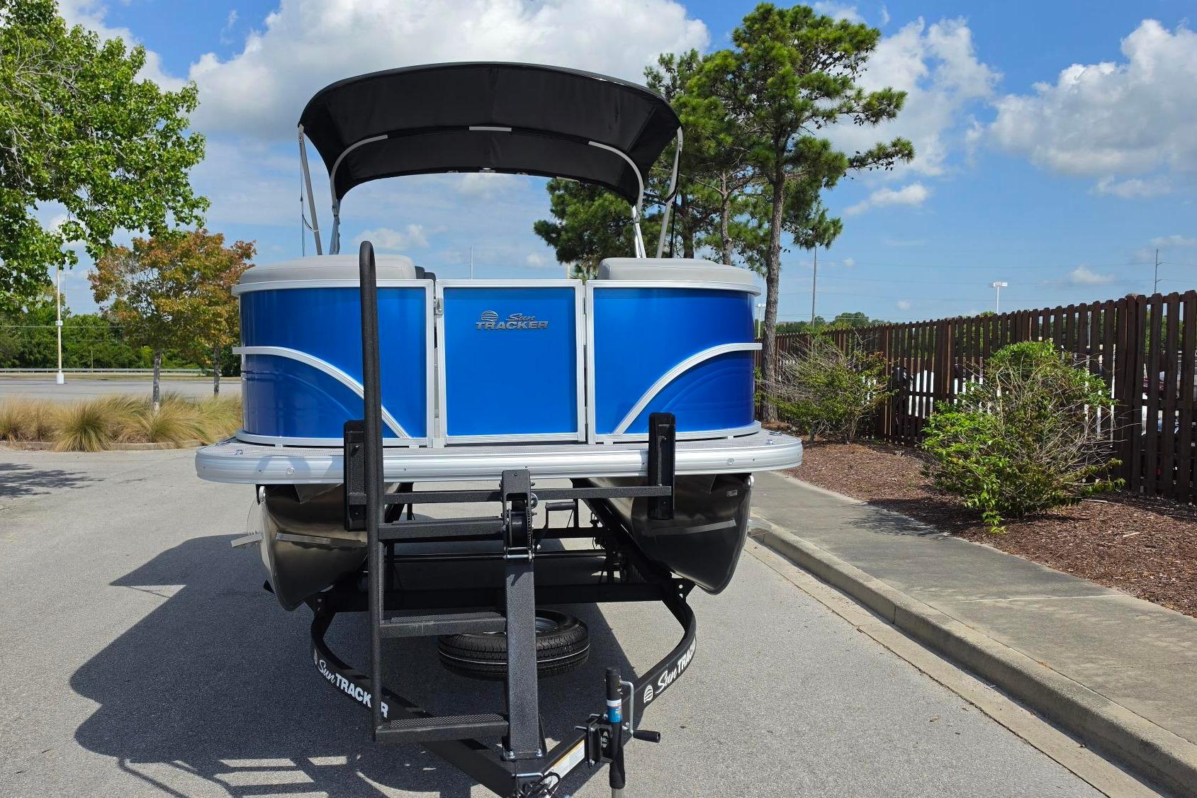 2026 Sun Tracker Party Barge 20 DLX pontoon boat on trailer, parked outdoors.