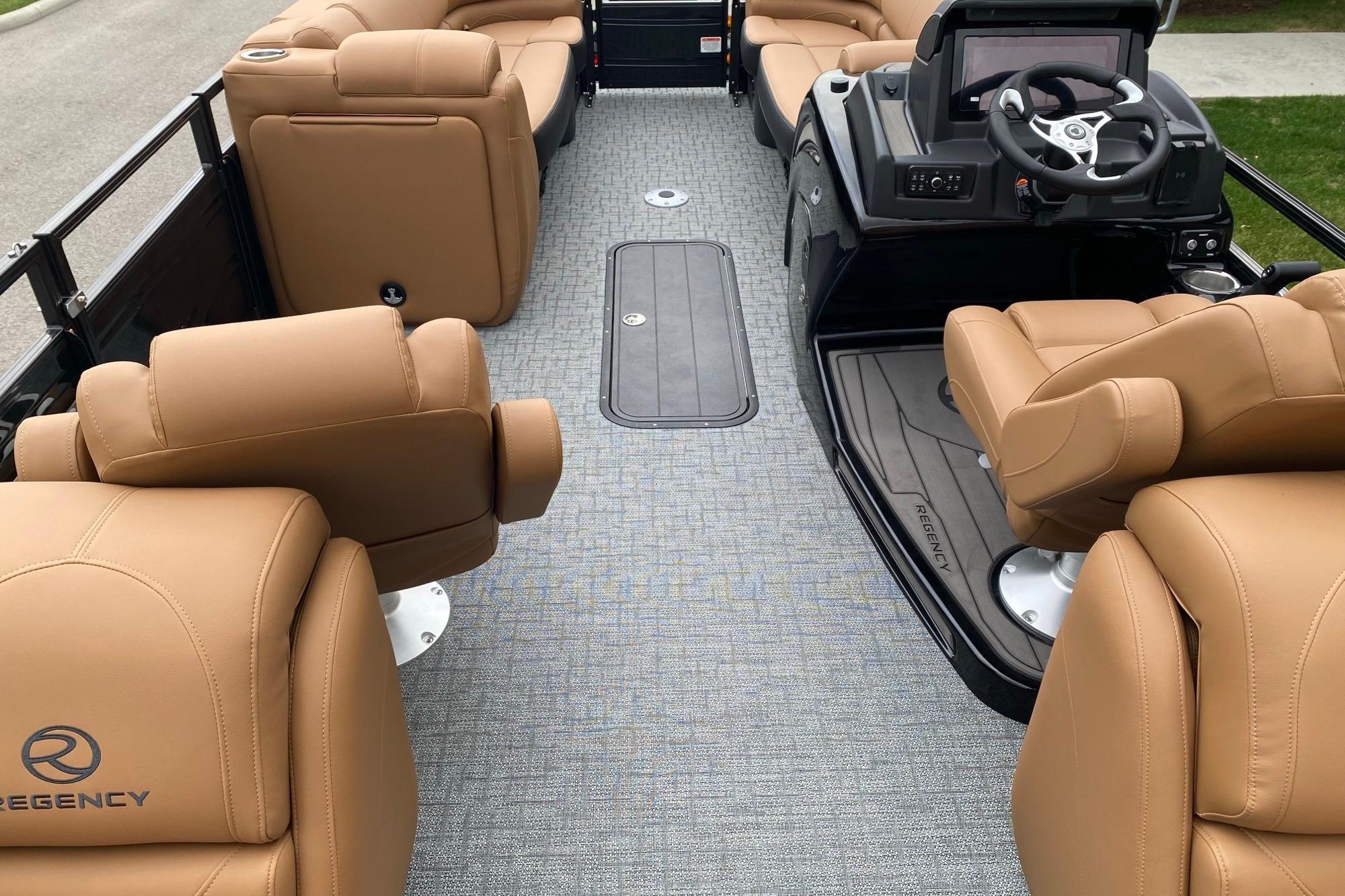 Luxurious interior of 2026 Regency 230 DL boat with tan leather seating and modern dashboard.