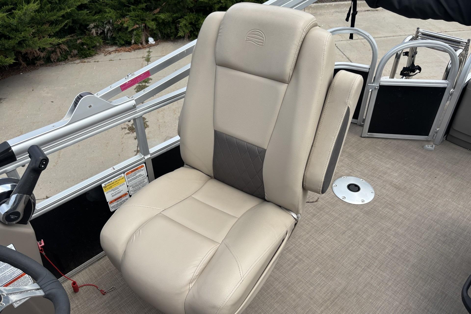 2023 Sun Tracker SportFish 20 DLX boat seat with beige upholstery and armrest.