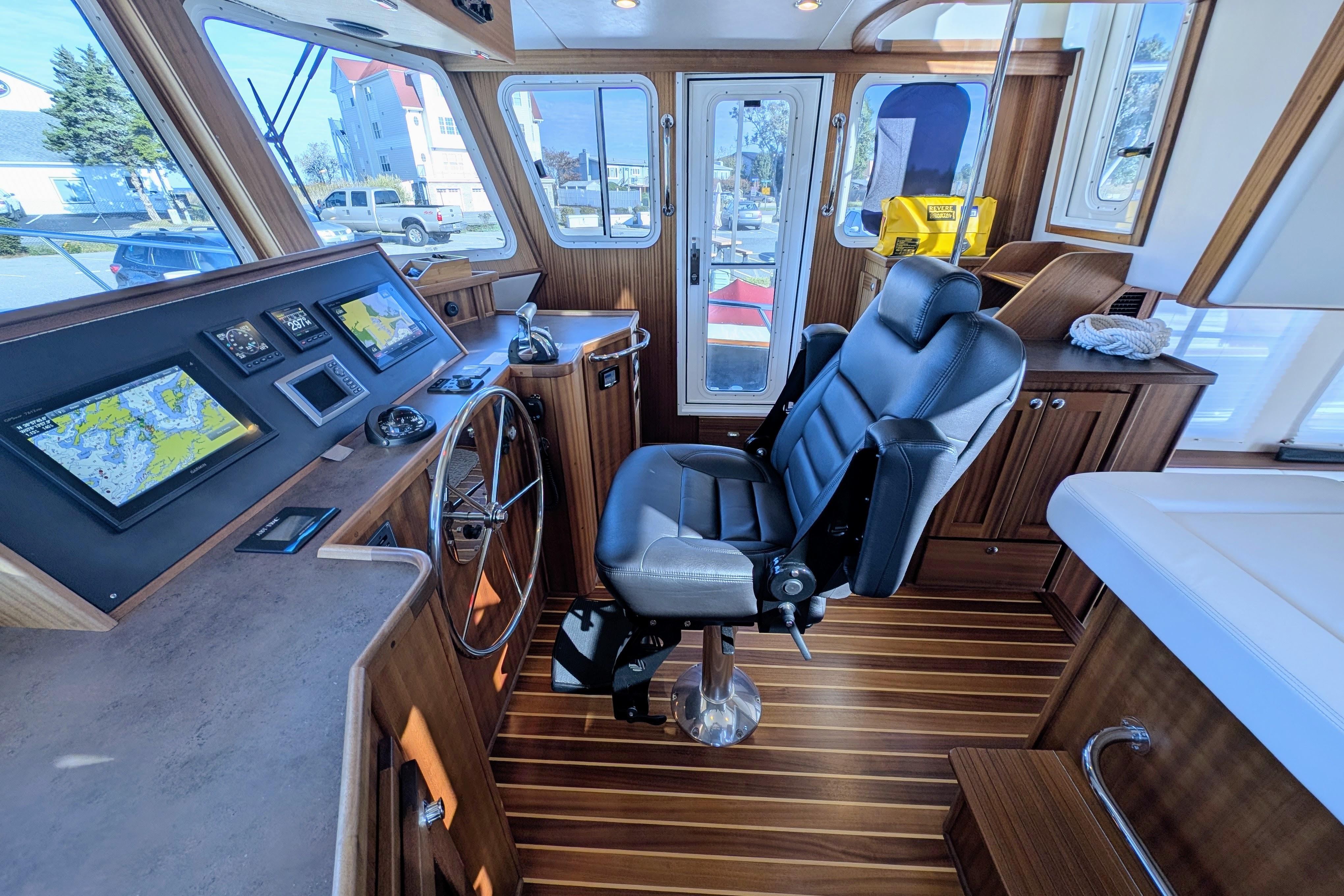 Pilothouse of 2015 American Tug 435 with navigation screens and captain's chair.