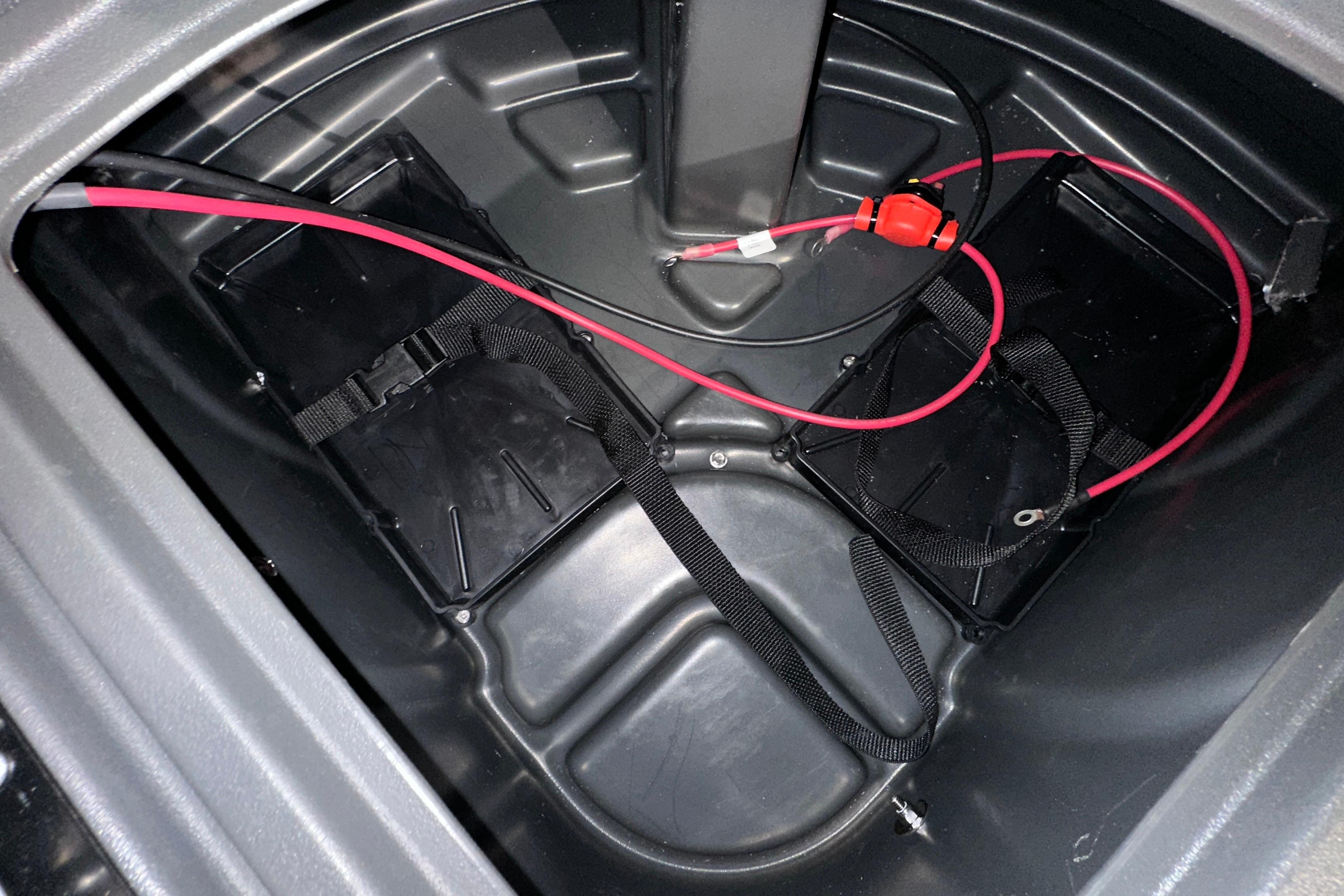 Battery compartment of 2026 Sun Tracker SportFish 22 DLX with red wiring and straps.
