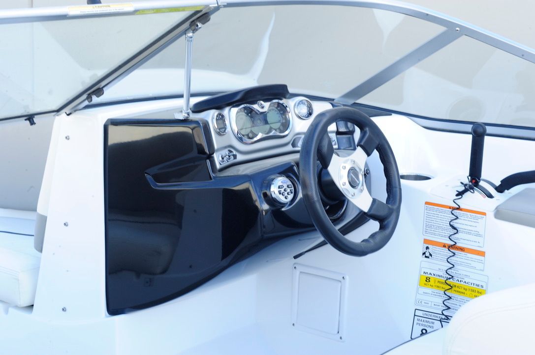 The image shows the cockpit of a 2011 Custom Challenger 180 boat with steering wheel and instruments.