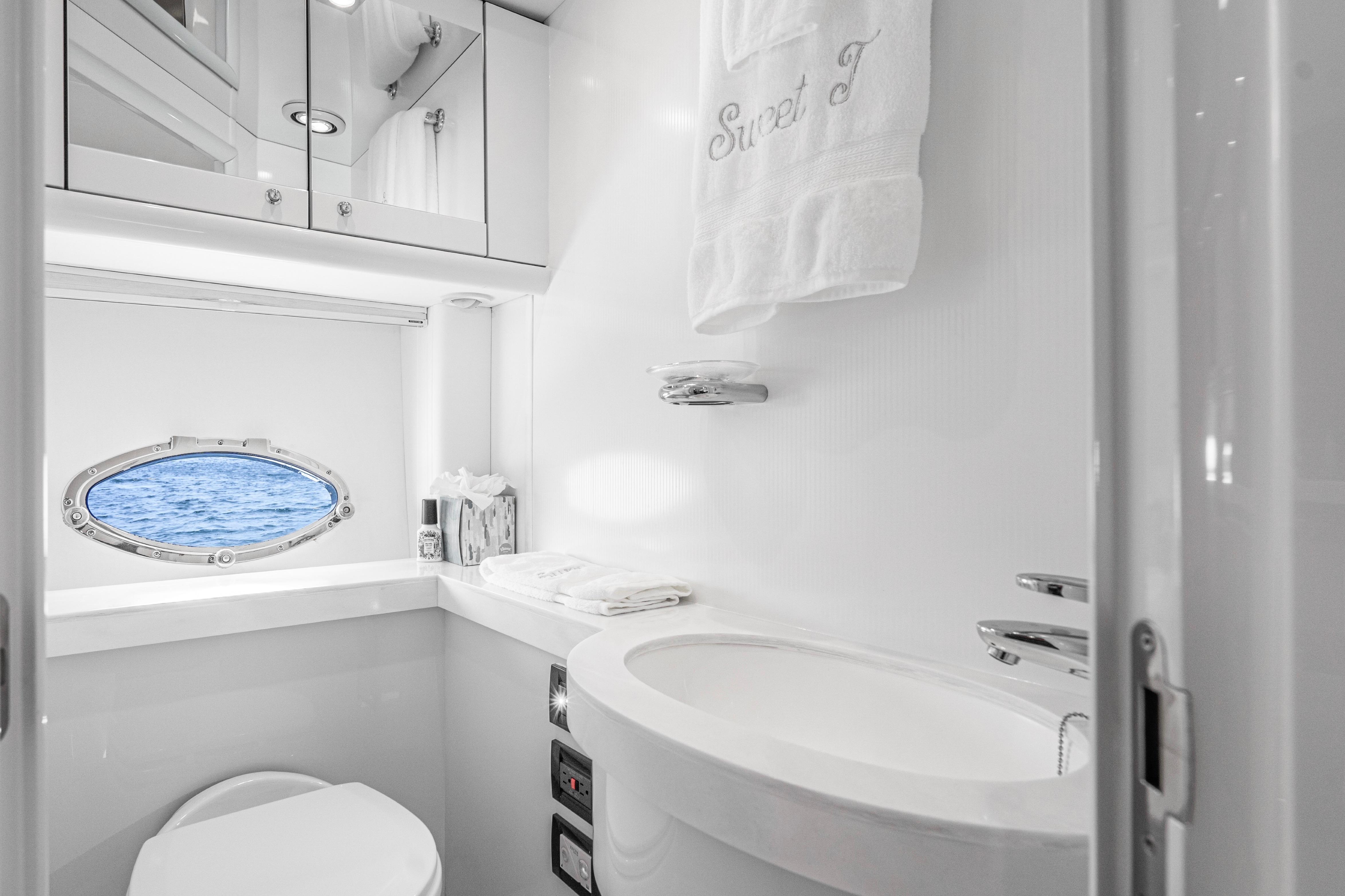 Luxurious bathroom in 2021 Sunseeker Predator 68 yacht with ocean view porthole.