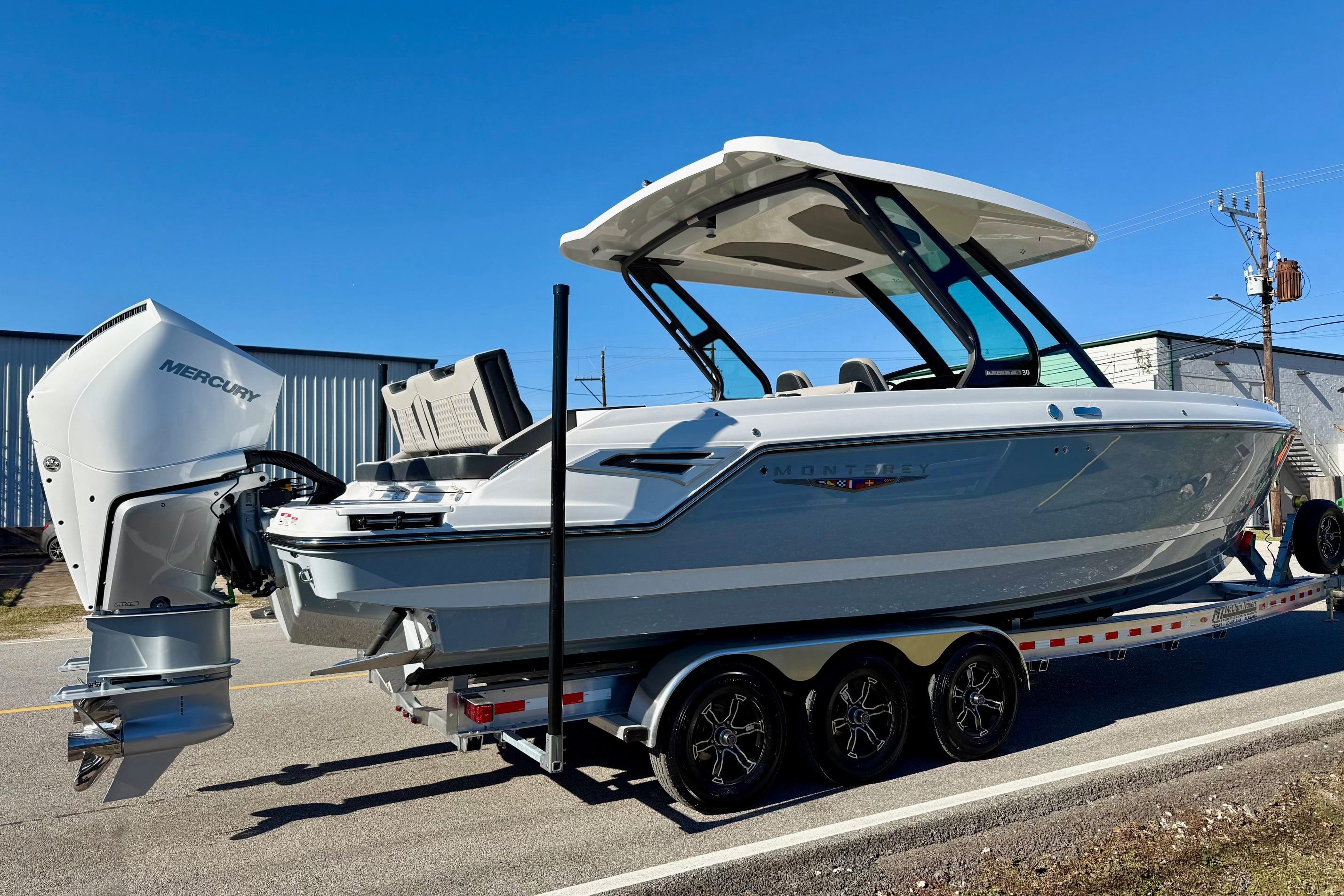 2026 Monterey Elite 30 OB boat on trailer, side view.