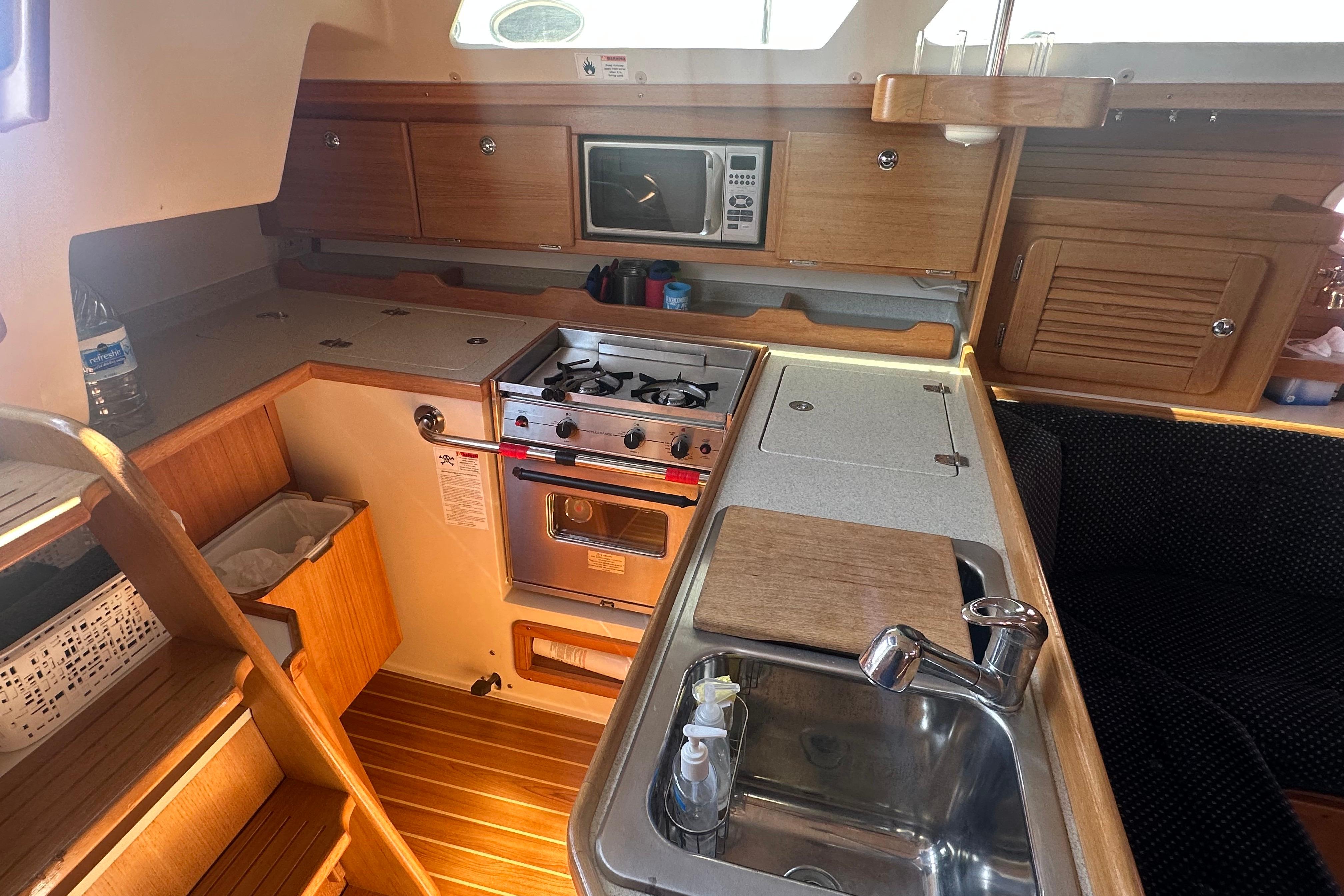 Cozy galley kitchen in 2005 Catalina 36 MkII sailboat with stove, sink, and microwave.