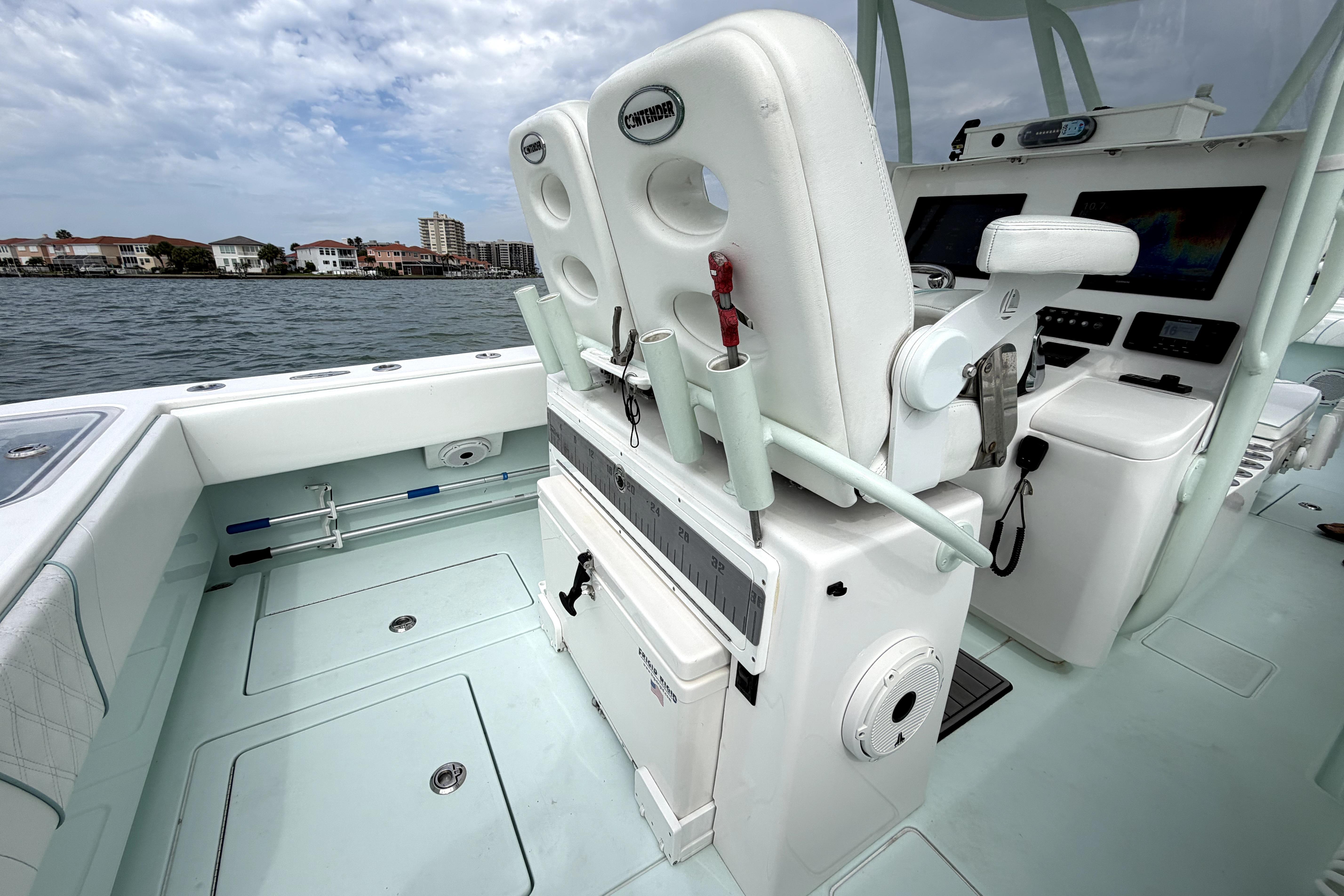 2019 Contender 30 ST boat interior with helm station and seating, docked near waterfront homes.