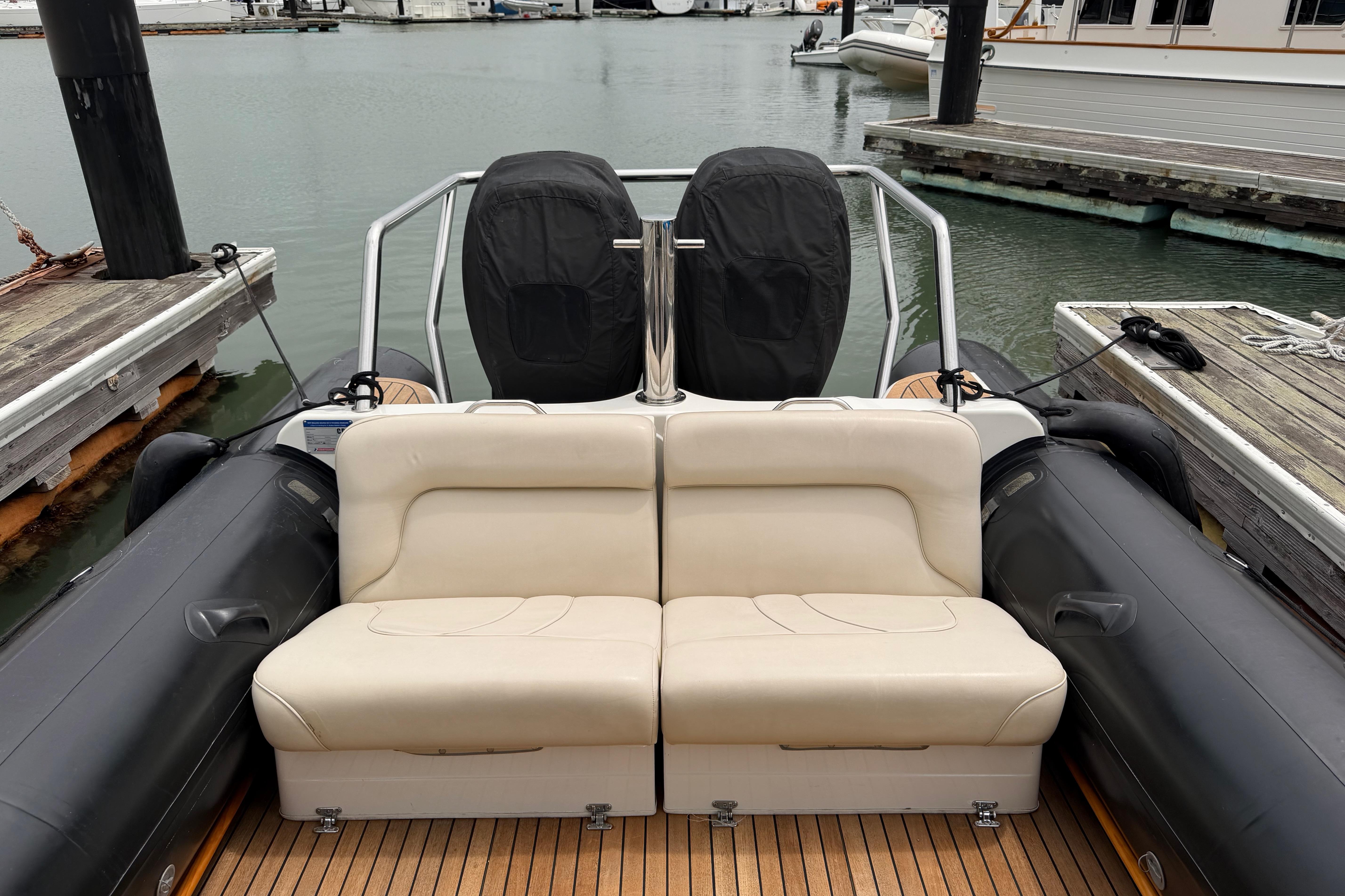 2016 Protector Targa 30 boat with beige seating at a marina dock.
