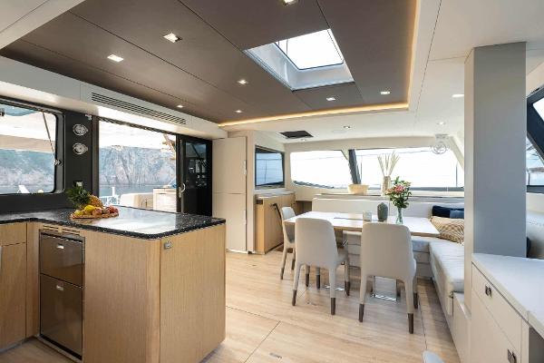 Luxurious interior of 2025 Privilege Signature 580 yacht with modern dining area and kitchen.