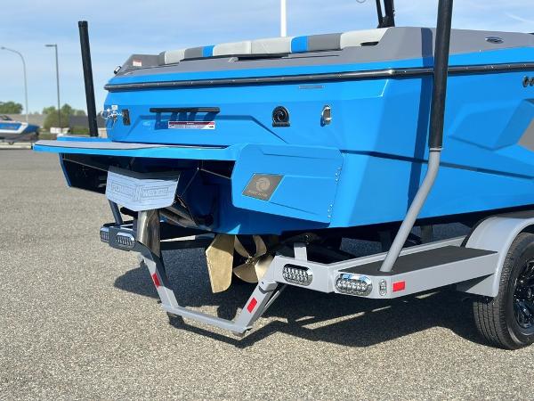 2025 Axis A225 boat rear view with propeller and trailer on pavement.