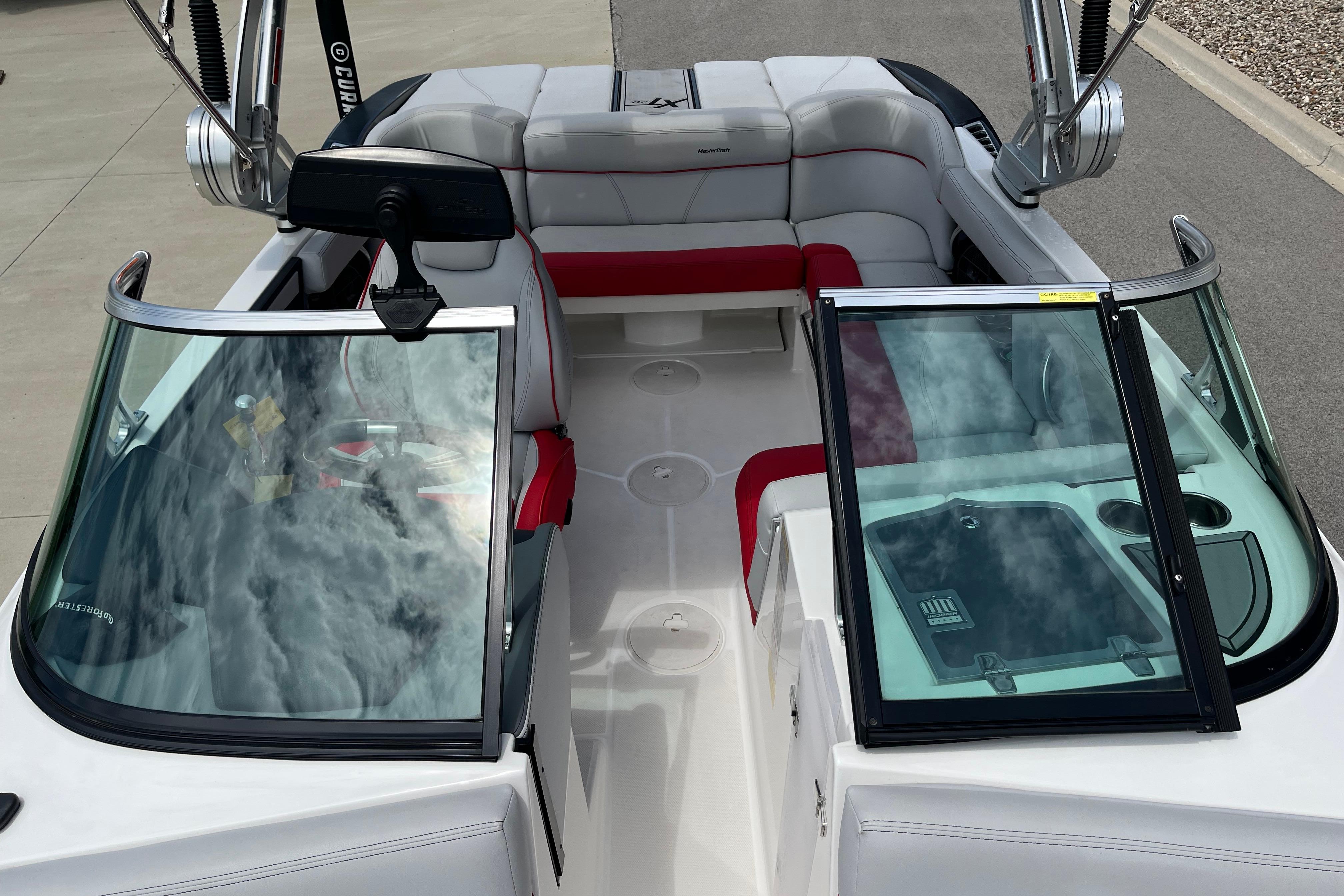 2019 MasterCraft XT20 boat interior with red and white seating, open windshield, and cup holders.
