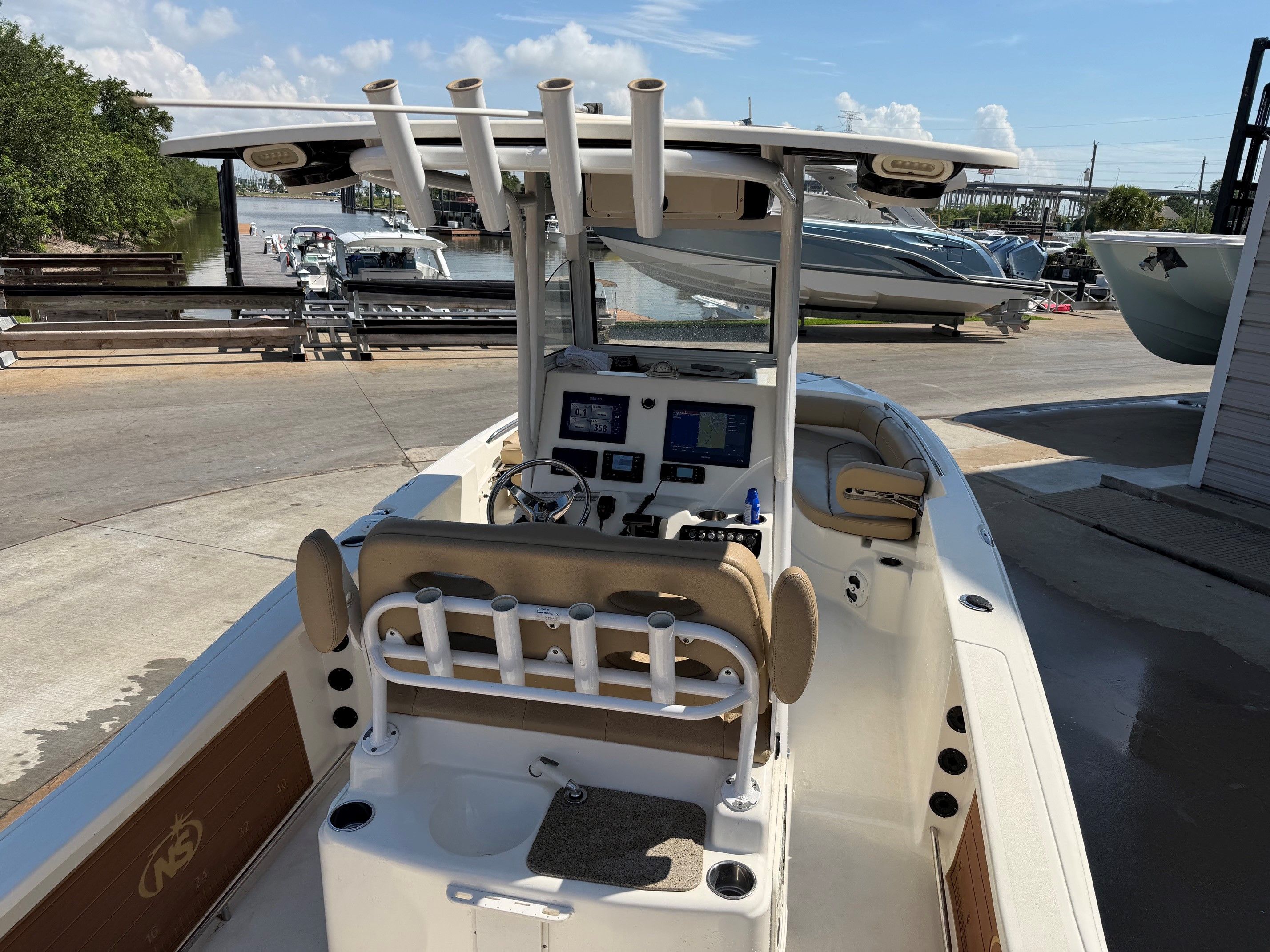 2019 NauticStar 251 Hybrid boat at dock with helm console.