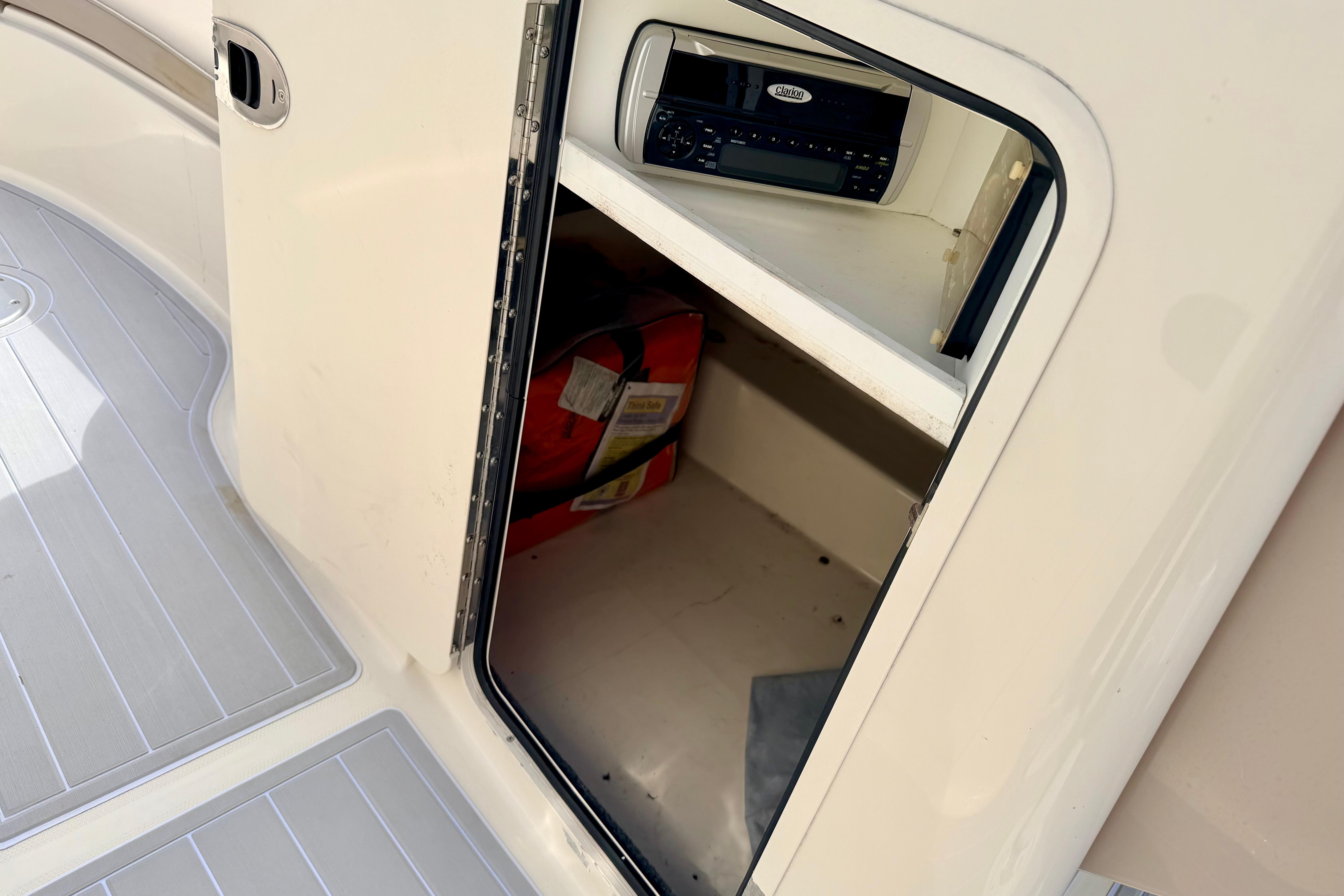 Storage compartment on a 2003 Sea Ray 200 Sundeck boat with stereo system.