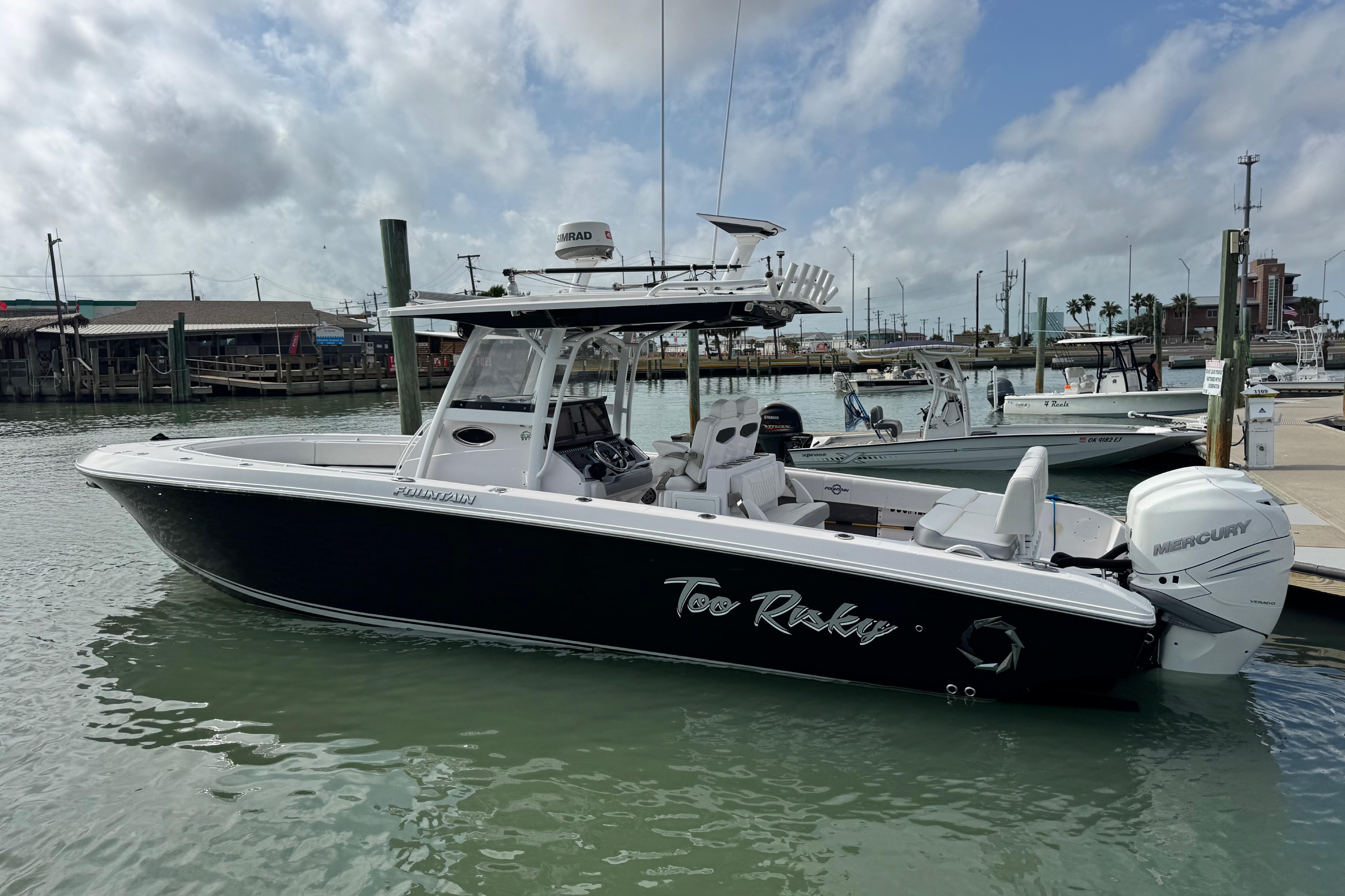 2018 Fountain 34 Center Console boat docked in marina, featuring sleek design and Mercury engines.