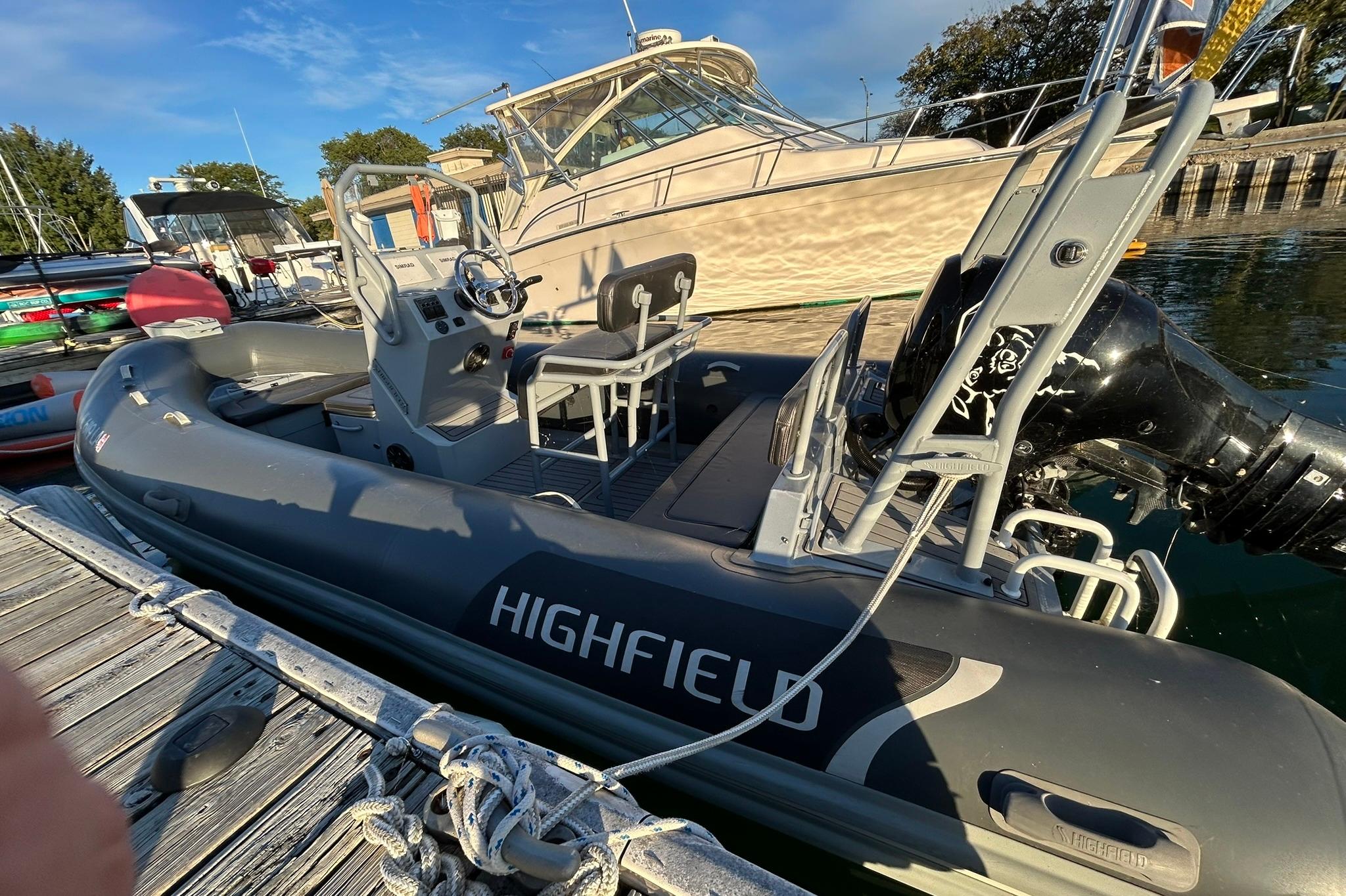 Highfield inflatable boat docked beside a 2007 Grady-White Express 360 yacht.