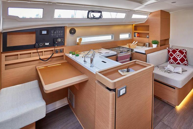 2024 Jeanneau Sun Odyssey 410 interior with modern kitchen, seating area, and navigation station.