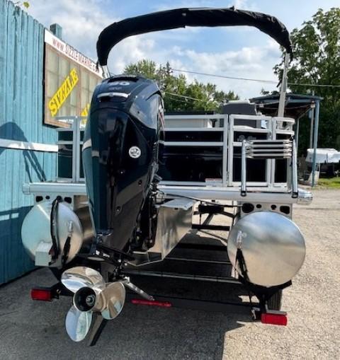 2026 Sun Tracker Fishin' Barge 20 DLX pontoon boat with outboard motor, parked outdoors.
