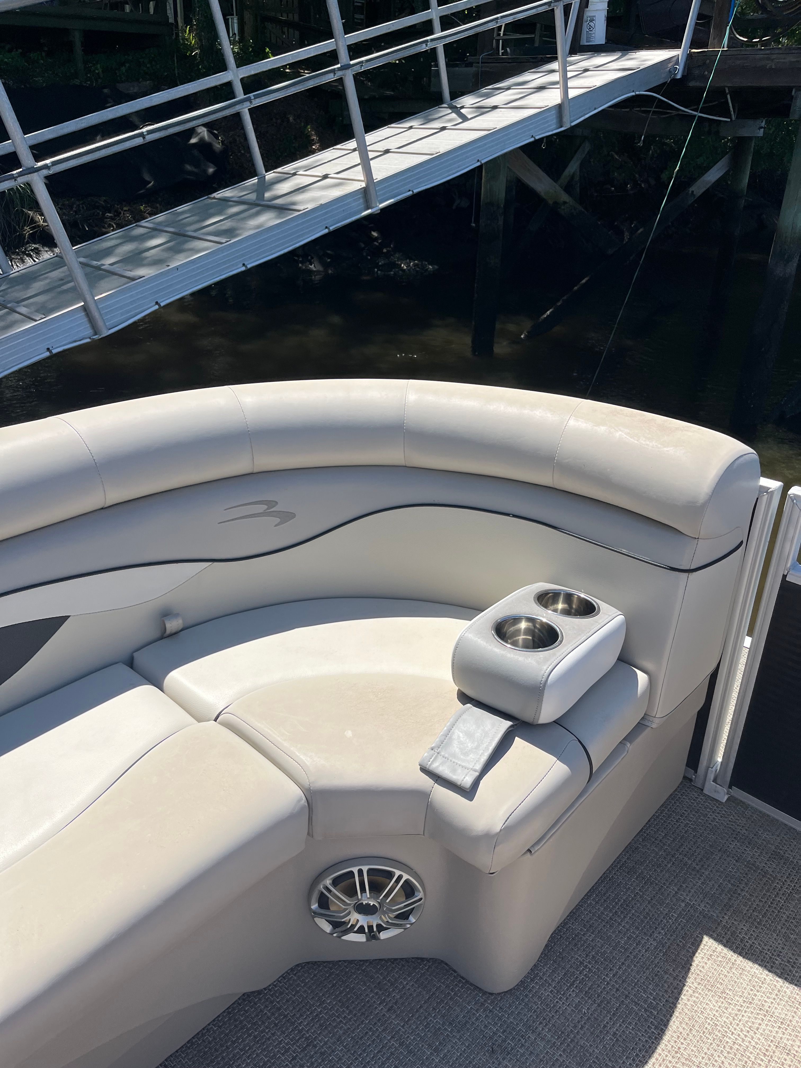 The image shows a cushioned bench seat on a boat with cup holders.