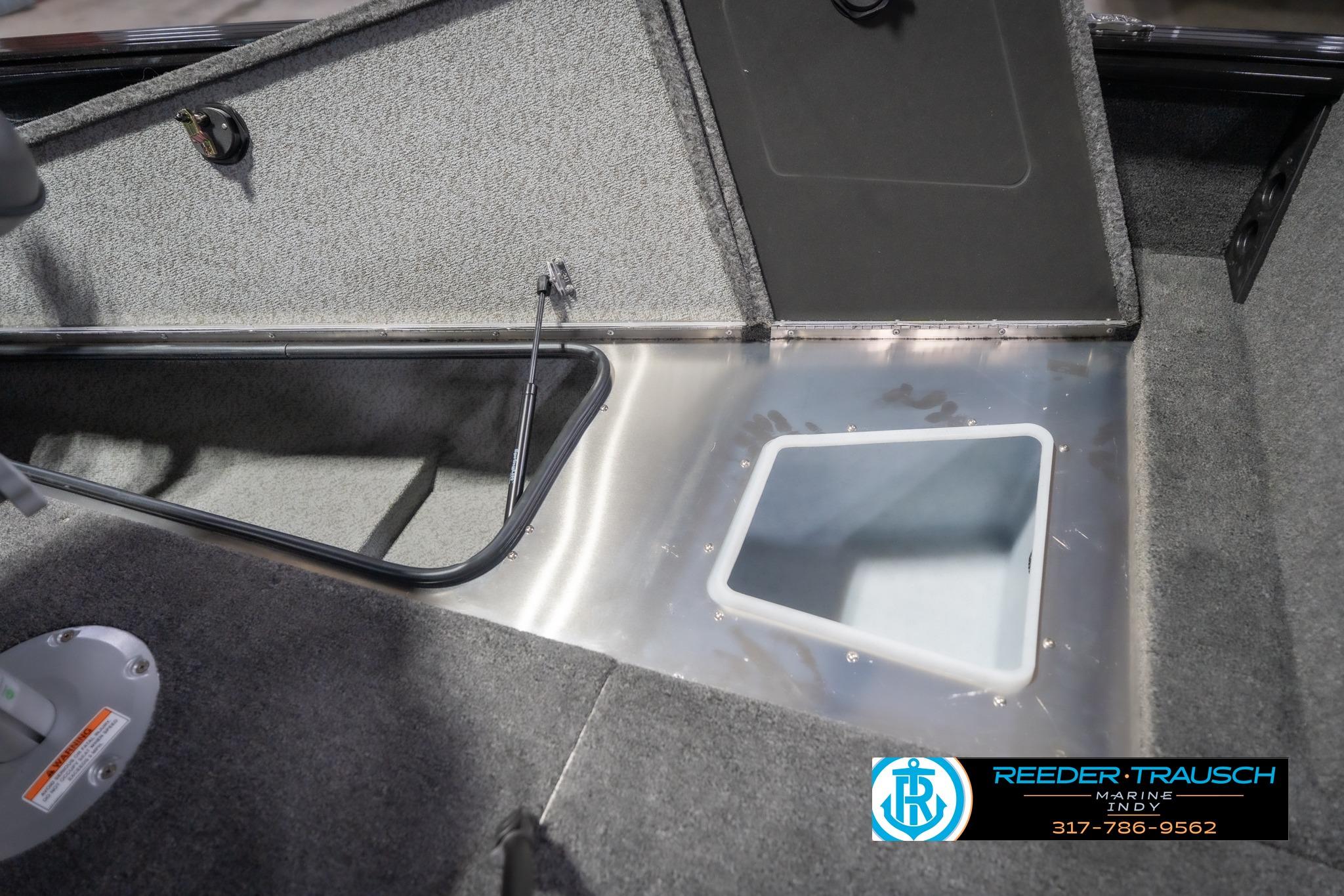 2026 Lund 2075 Impact XS boat interior with storage compartment and carpeted flooring.