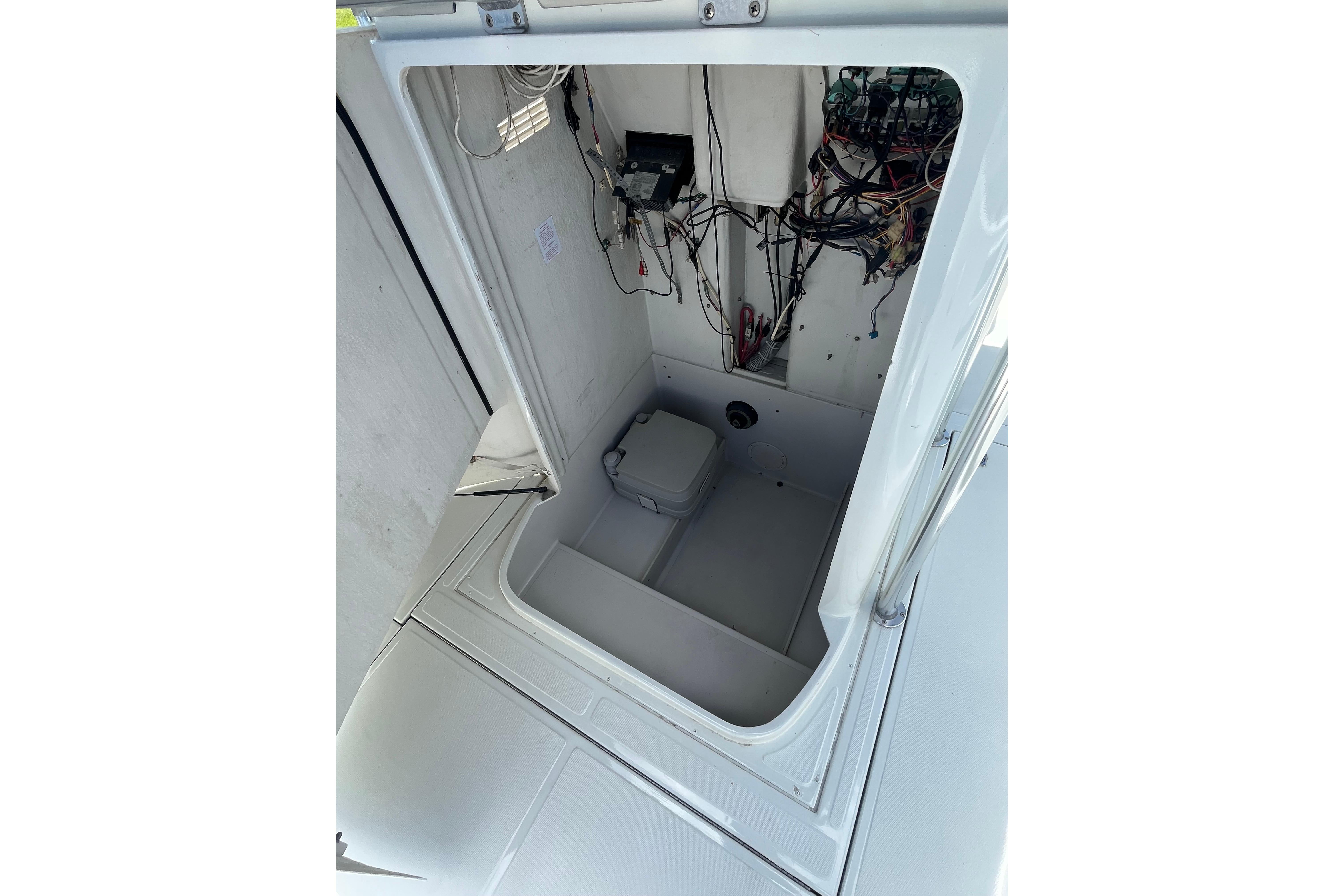 1997 Stamas boat interior showing wiring and a compact toilet.