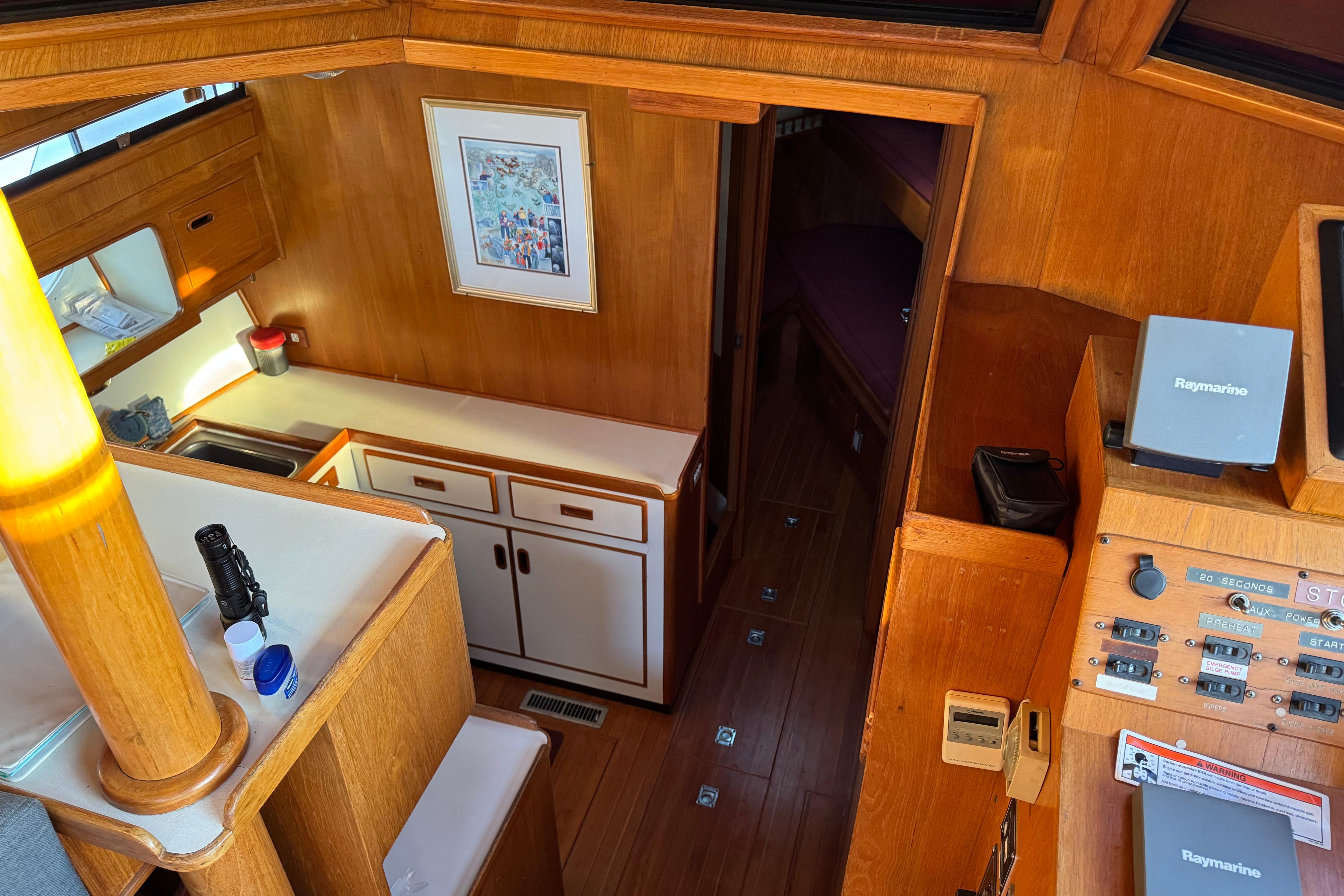 Interior of a 1987 President 37 yacht with wood paneling and navigation equipment.