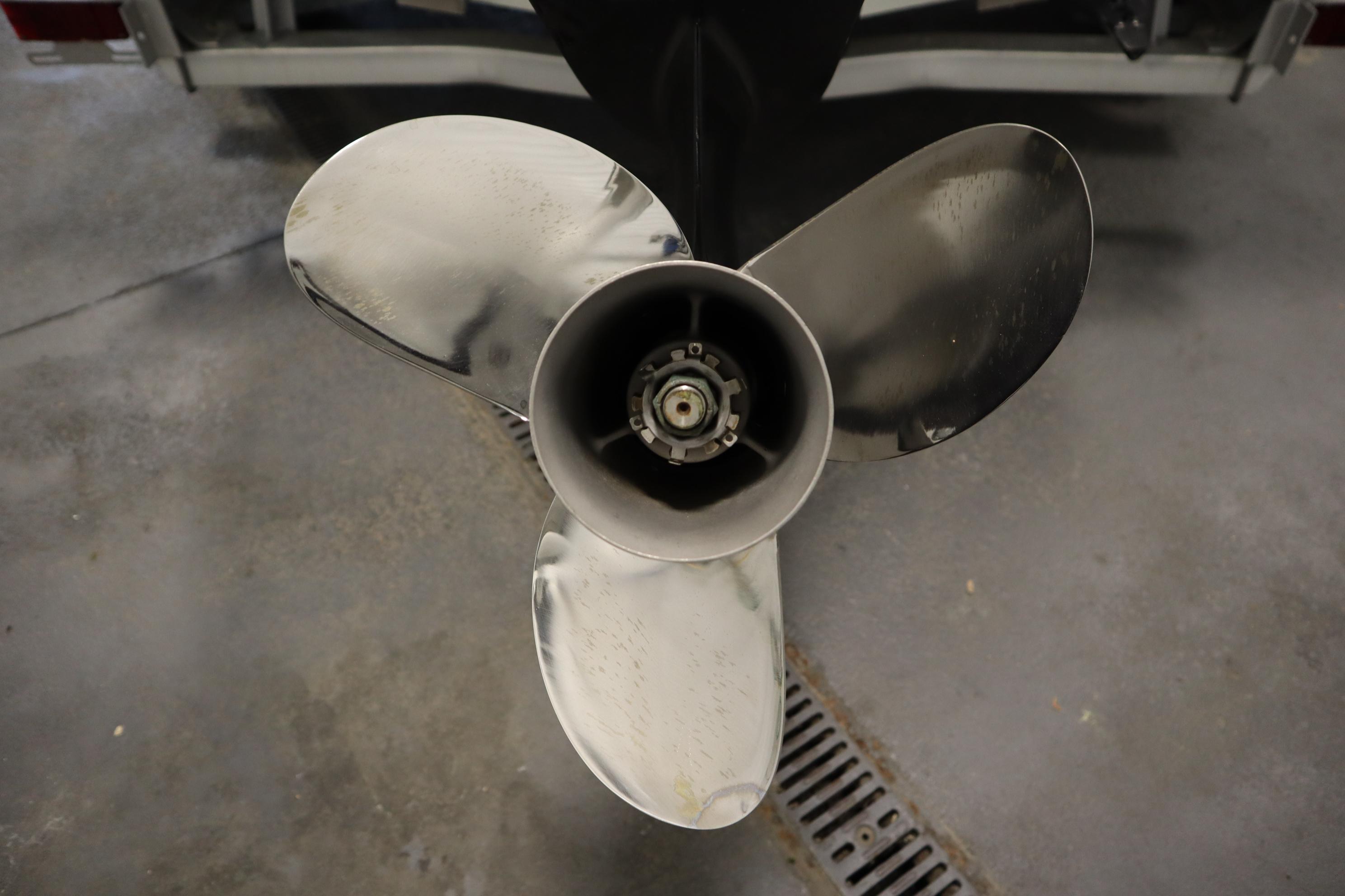 Close-up of a 2022 Crestliner 2200 CC boat propeller in a garage setting.