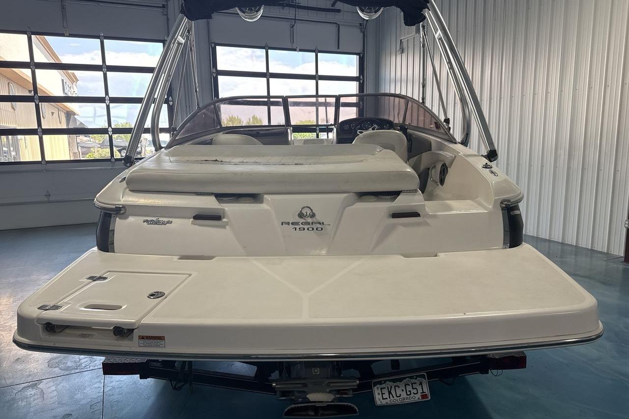 2012 Regal 1900 Bowrider boat in a garage, rear view with swim platform.