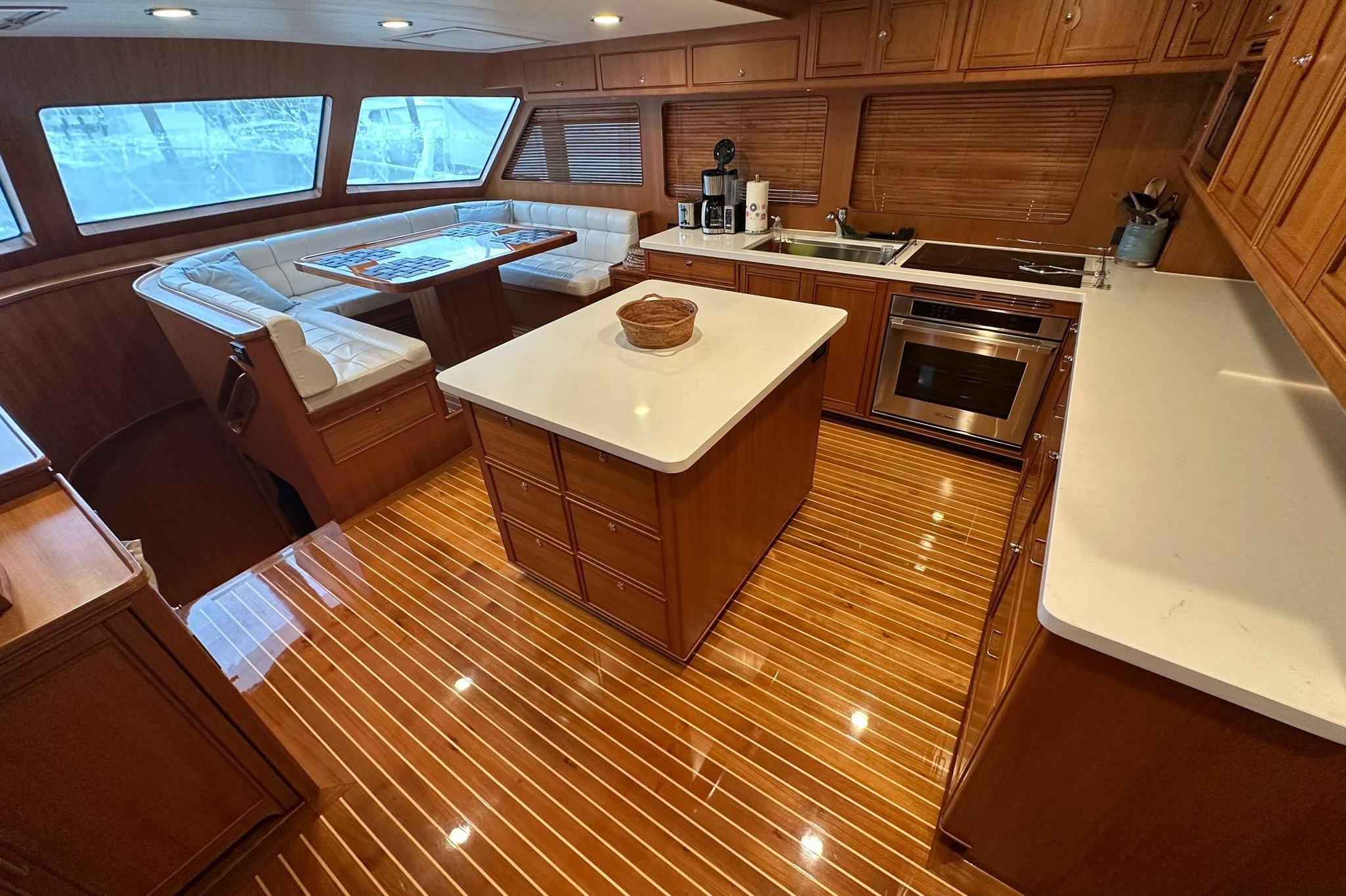 Luxurious 2023 Marlow Explorer 66E-CB yacht interior with modern kitchen and dining area.