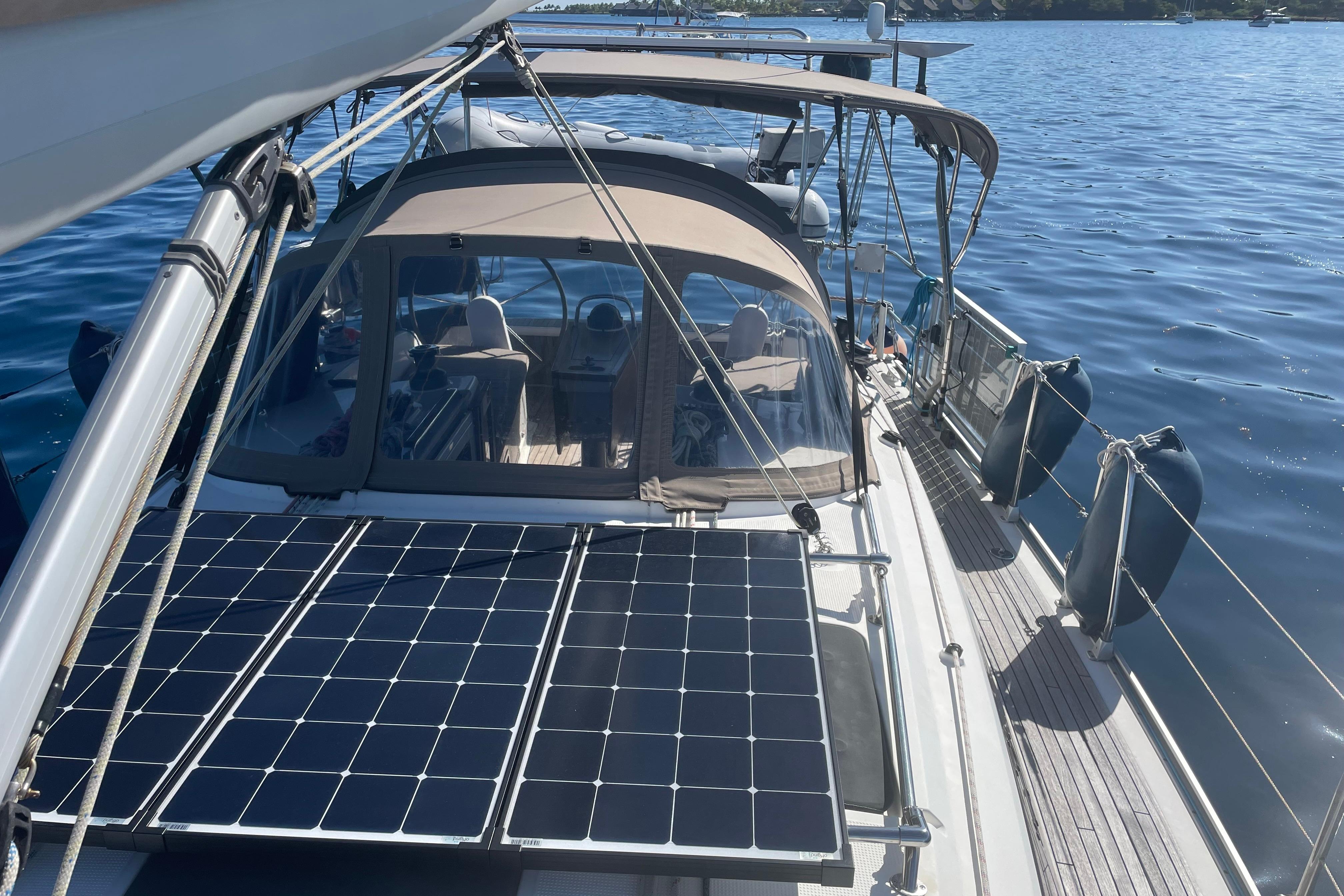 2014 Bavaria Cruiser 37 sailboat with solar panels on deck, anchored on calm water.