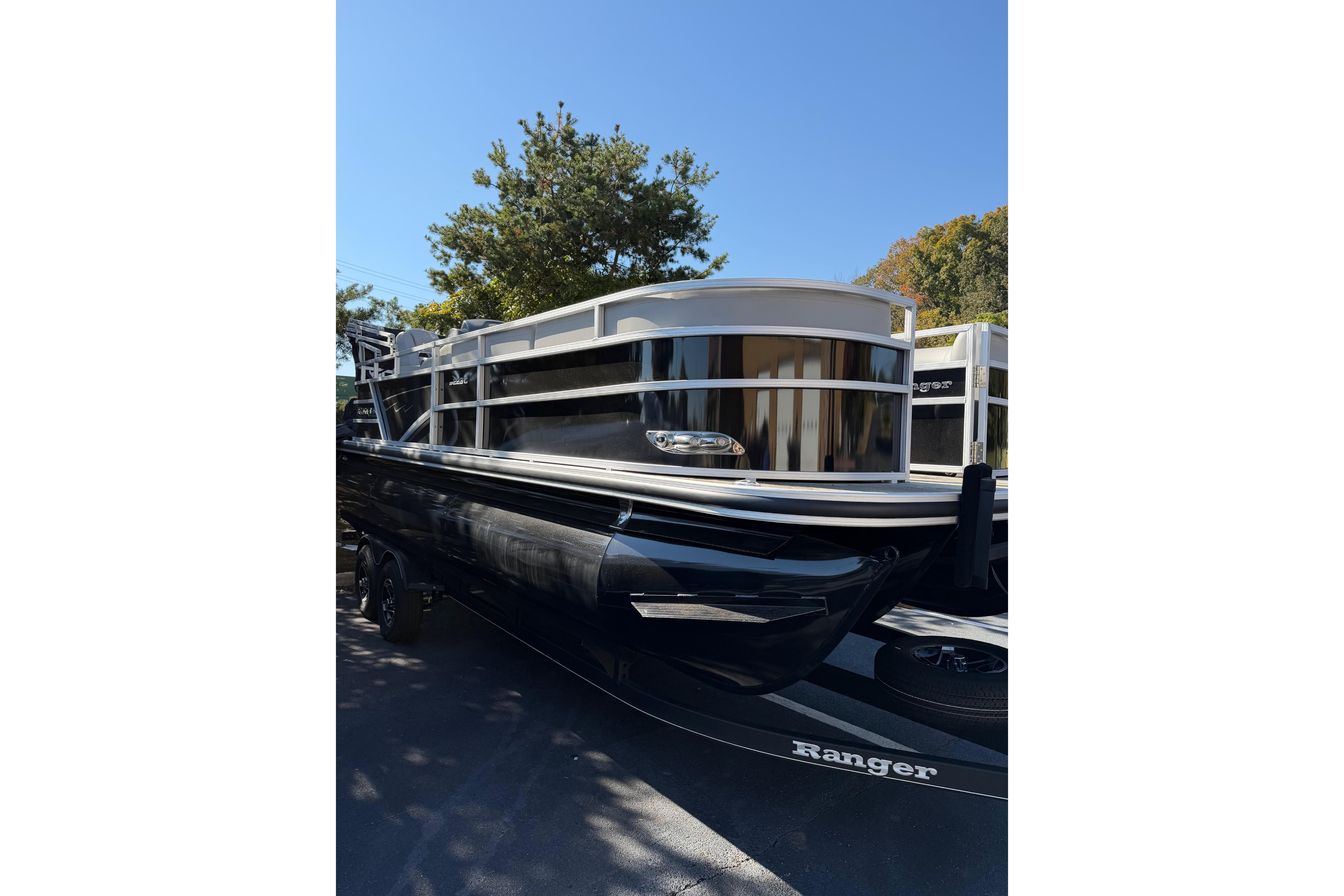 2024 Ranger Reata 223C pontoon boat with sleek black design, parked outdoors.