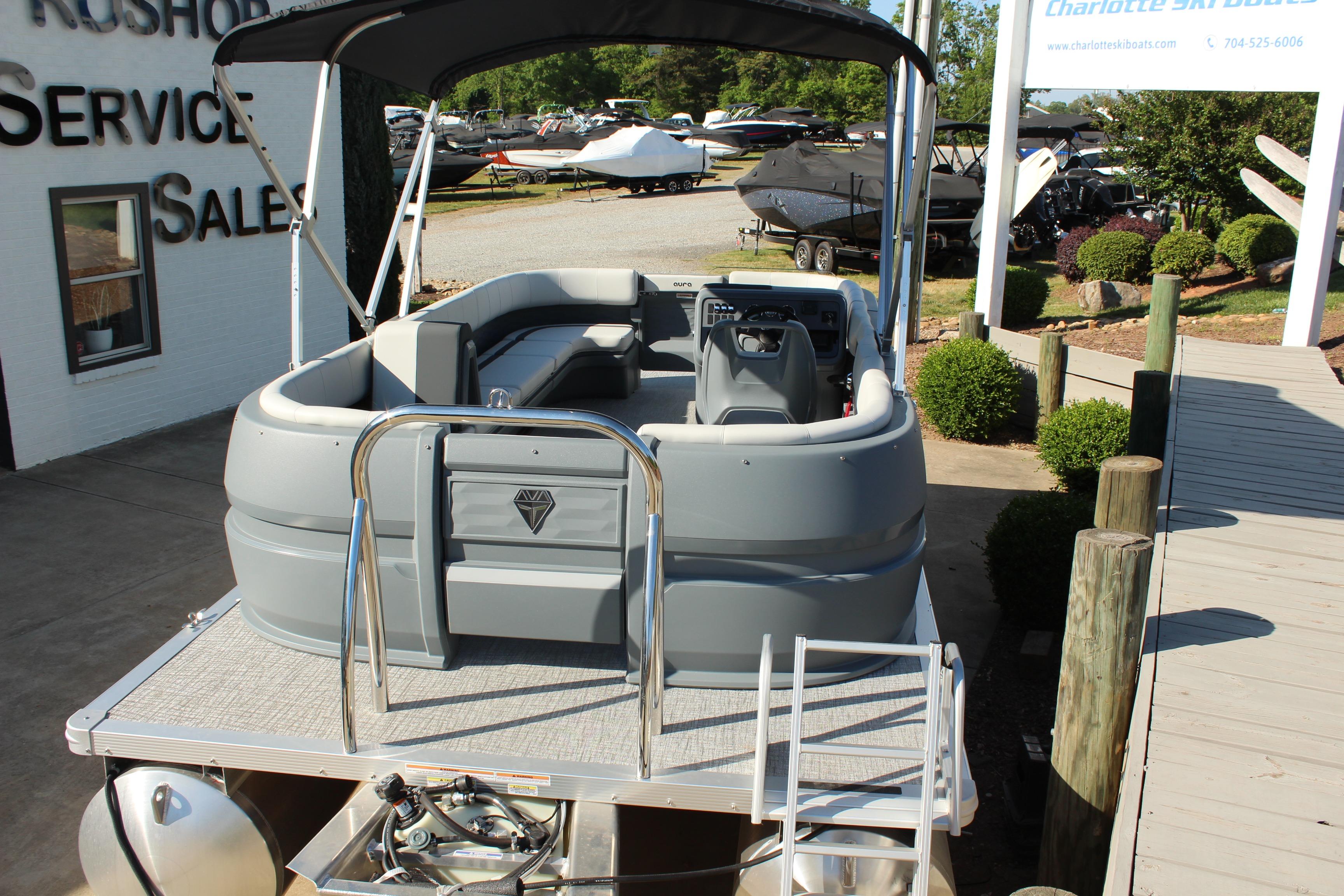 2026 Tahoe Pontoon Aura boat displayed at a dealership with a sleek, modern design.