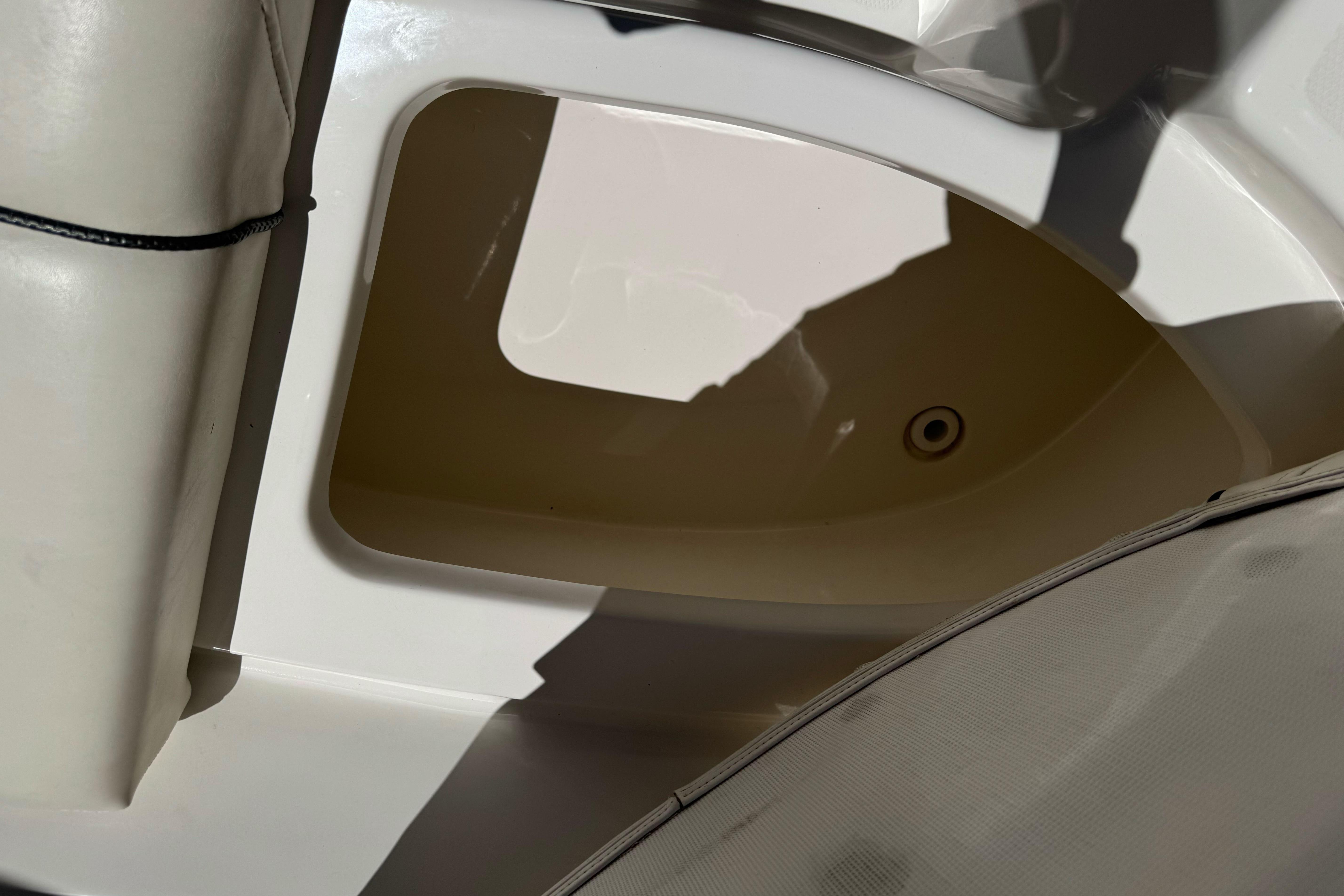Storage compartment in a 2007 Sea Ray SLX 250 boat, featuring white interior.