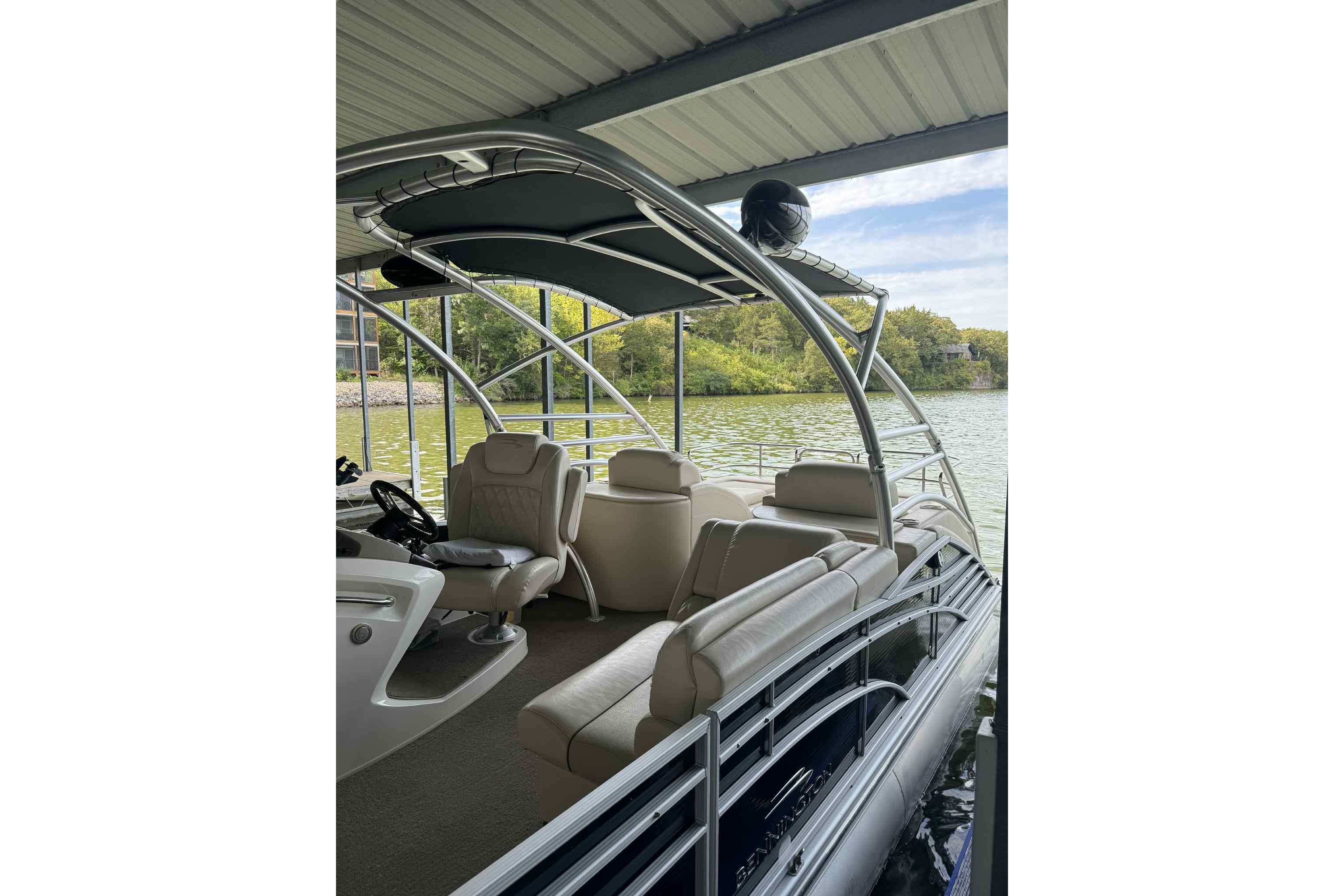 2014 Bennington 2875 QCW I/O pontoon boat docked, featuring spacious seating and sleek design.