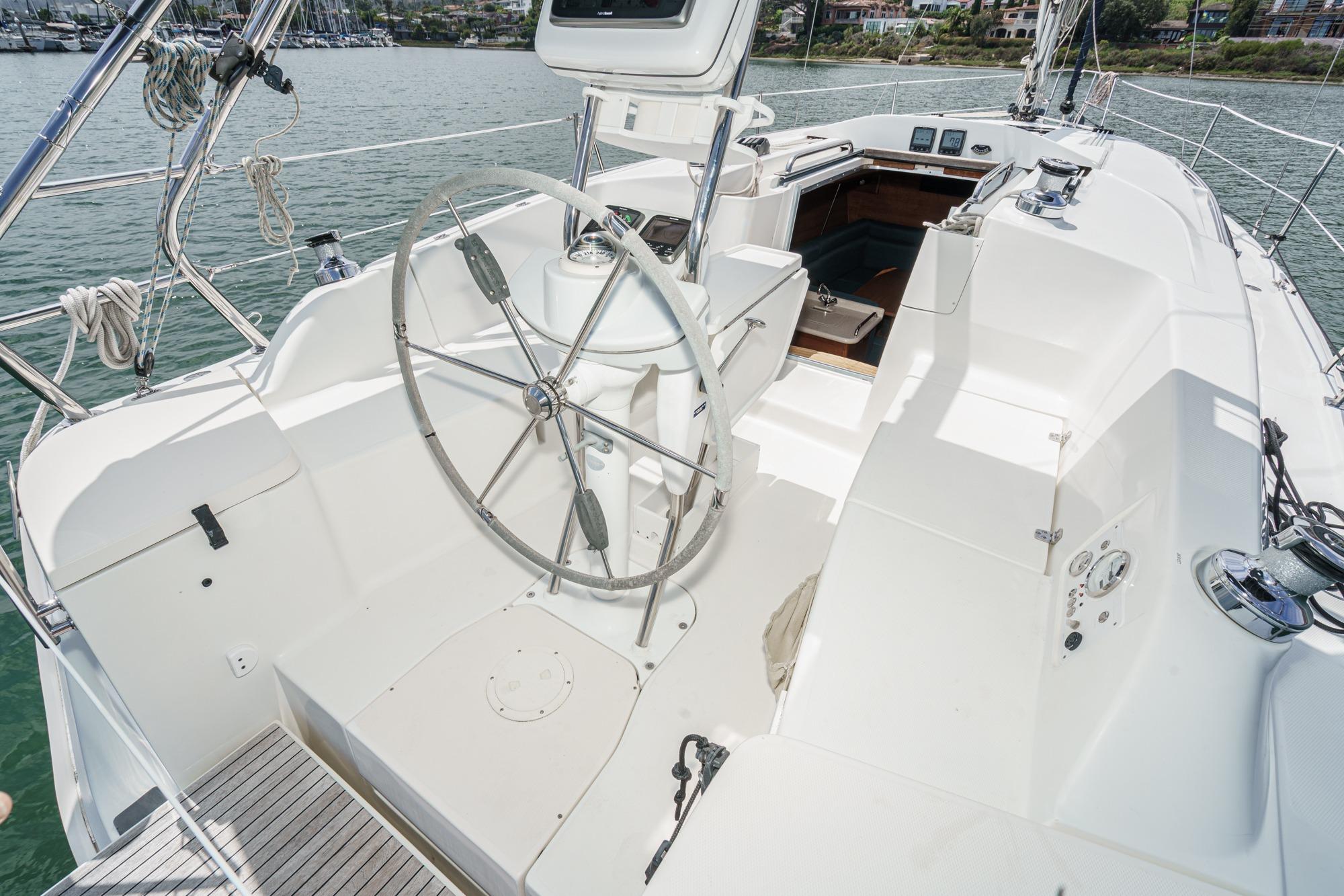 2015 Hunter 33 sailboat cockpit with steering wheel, docked in marina.