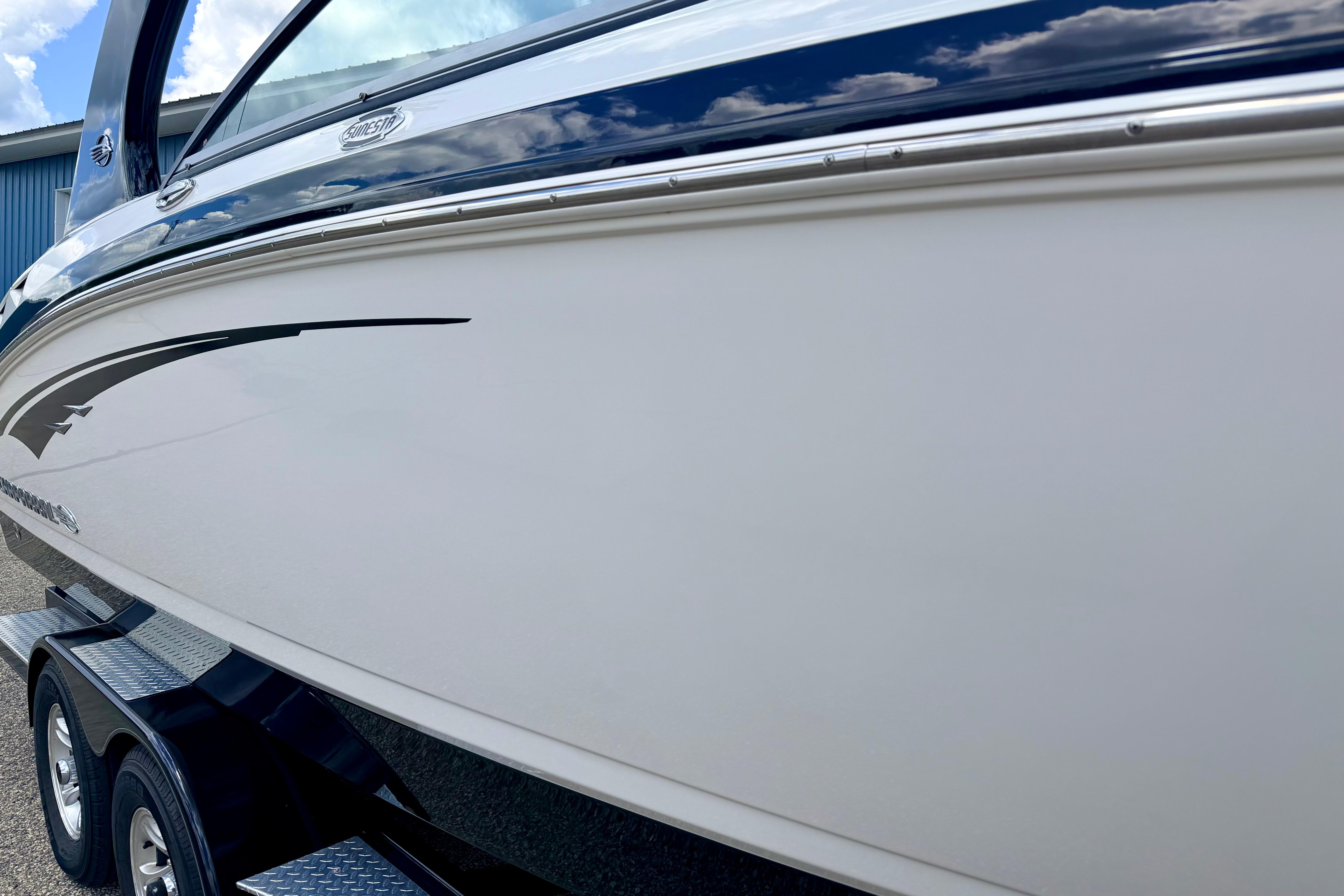 2015 Chaparral Sunesta 264 boat side view with sleek design and trailer.