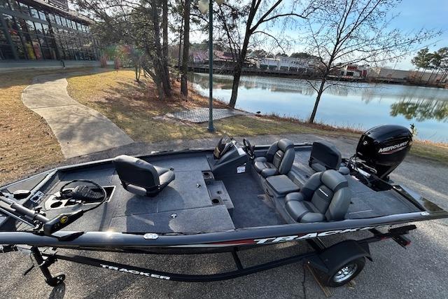 2026 Tracker Pro Team 175 boat by a lakeside, featuring sleek design and comfortable seating.