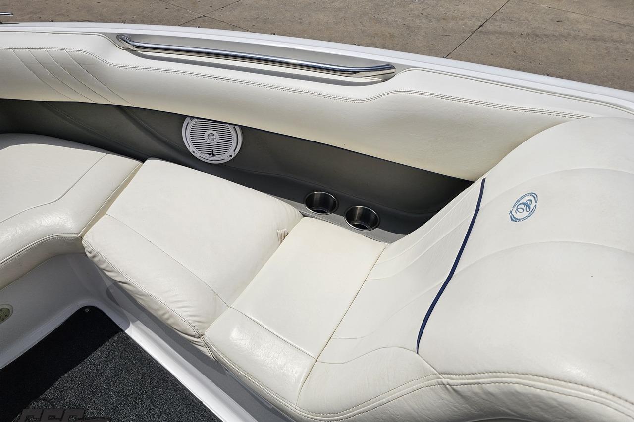 Interior of 2010 Cobalt 232 WSS boat with white leather seating and speaker.