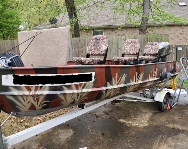 1973 Alumacraft V hull boat with camouflage seats on a trailer.