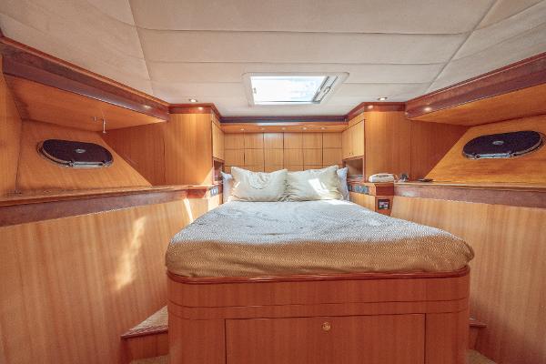 Luxurious bedroom interior of 2001 Grand Harbour 76 yacht with skylight and wooden finishes.