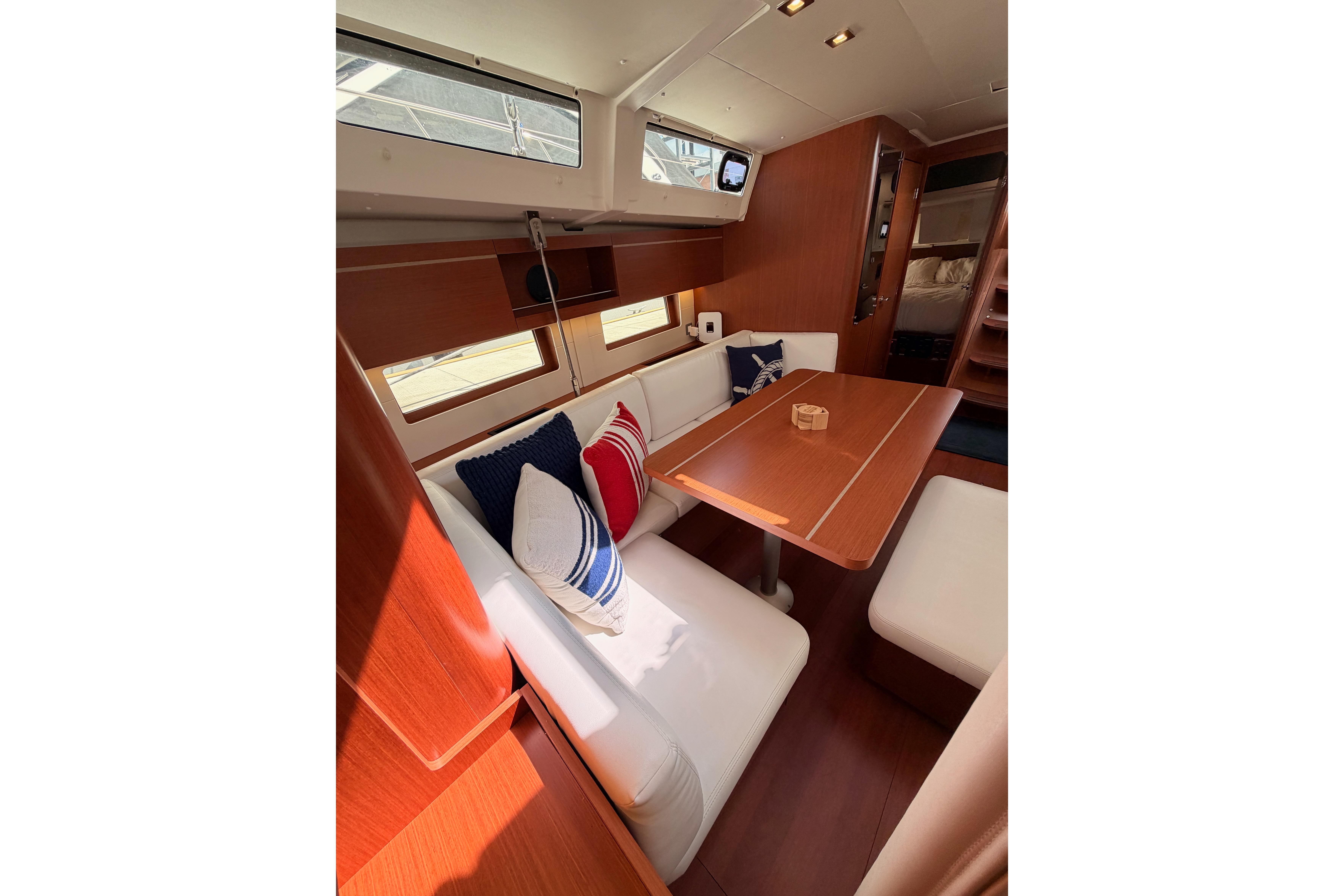 Interior of 2020 Beneteau Oceanis 46.1 yacht with cozy seating and wooden table.