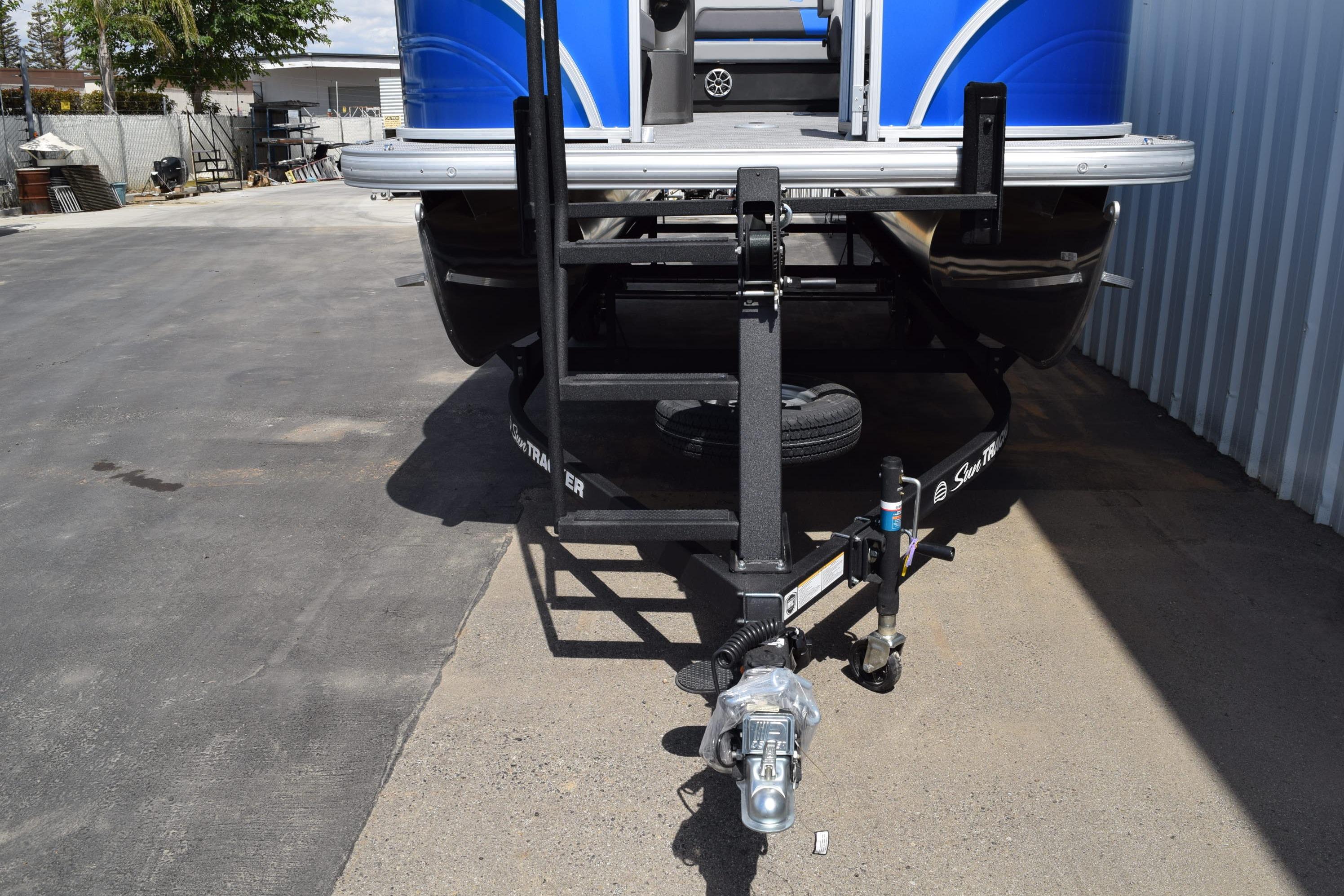 2026 Sun Tracker Party Barge 22 RF DLX on trailer, parked outdoors.