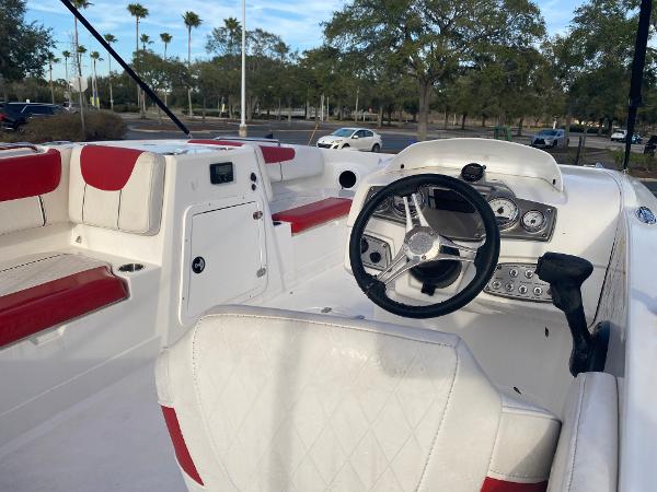 2022 Tahoe 2150 boat interior with red and white seating, steering wheel, and dashboard.