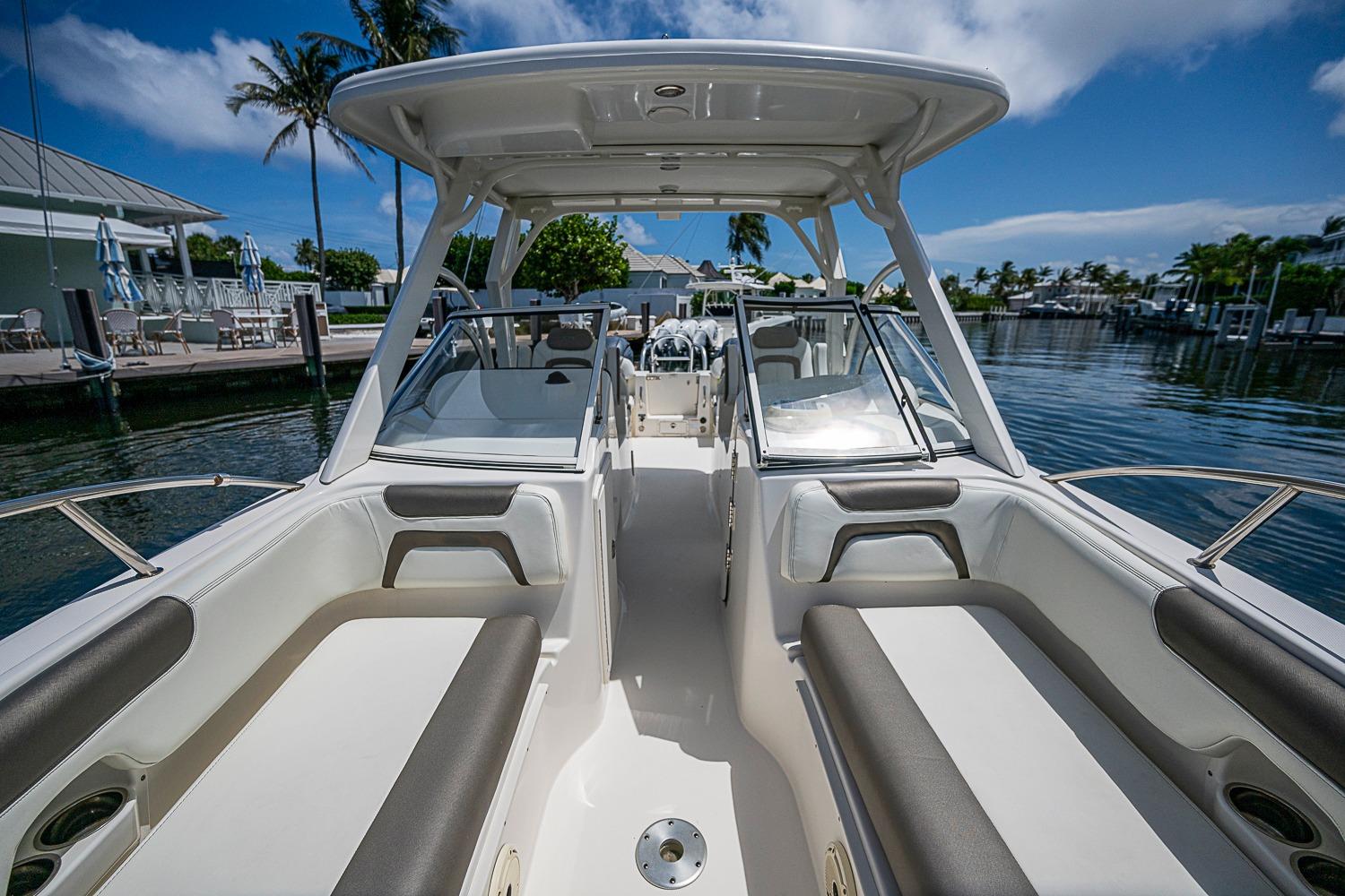 2020 WorldCat 255 DC boat interior with seating, docked by a marina under a clear blue sky.